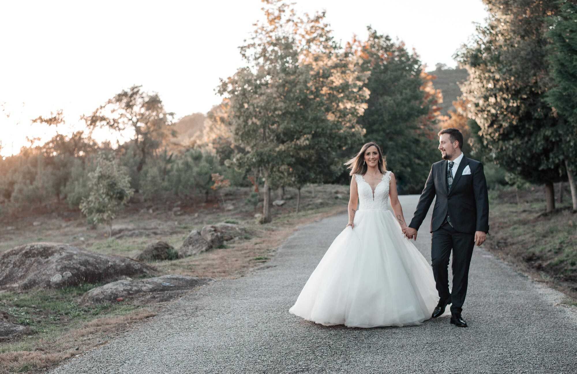 Casal a caminhar pela a estrada de mãos dadas