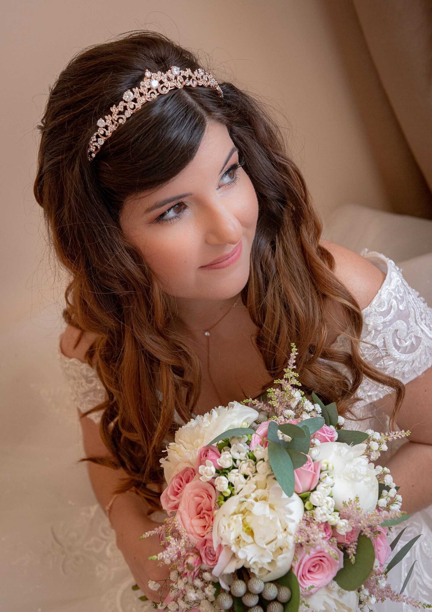 Noiva sentada na cama enquanto segura o buque