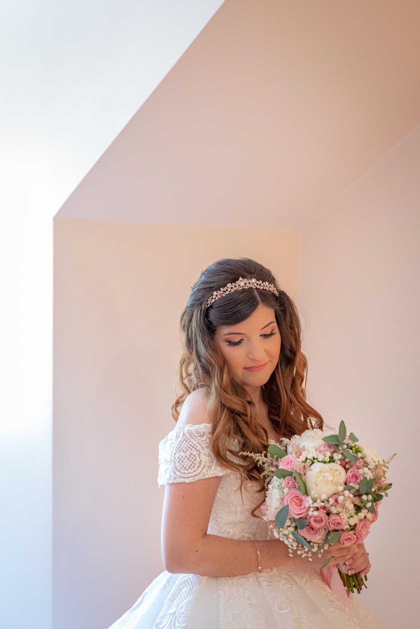 Noiva a olhar para o chão e com o buque nas mãos