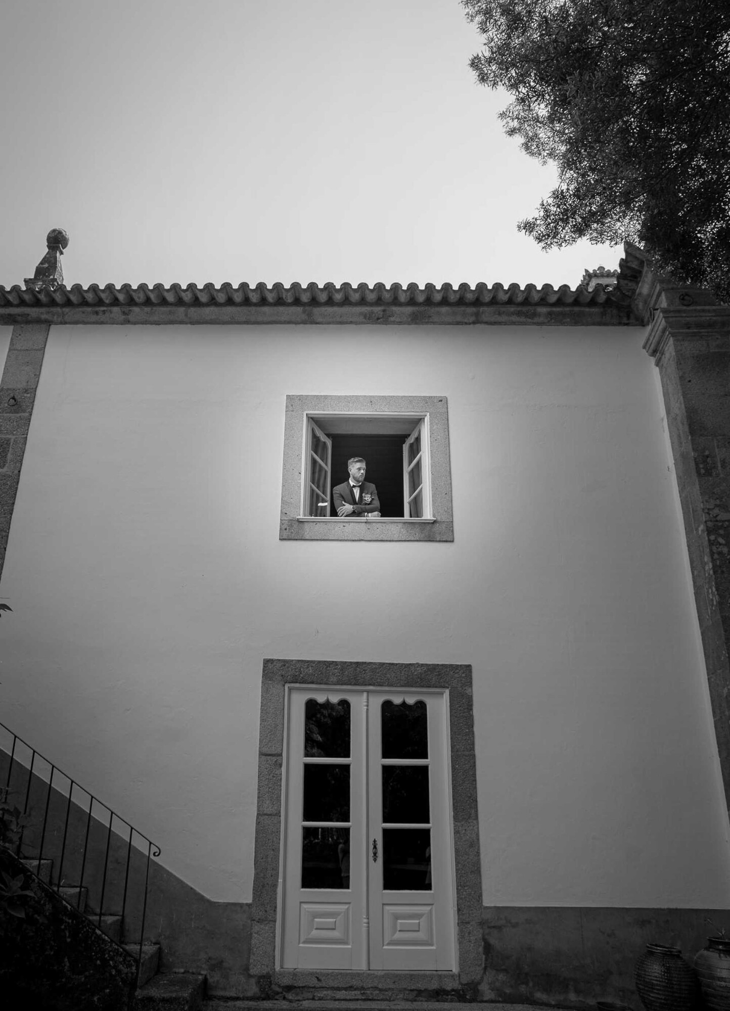 Noivo na janela de braços cruzados