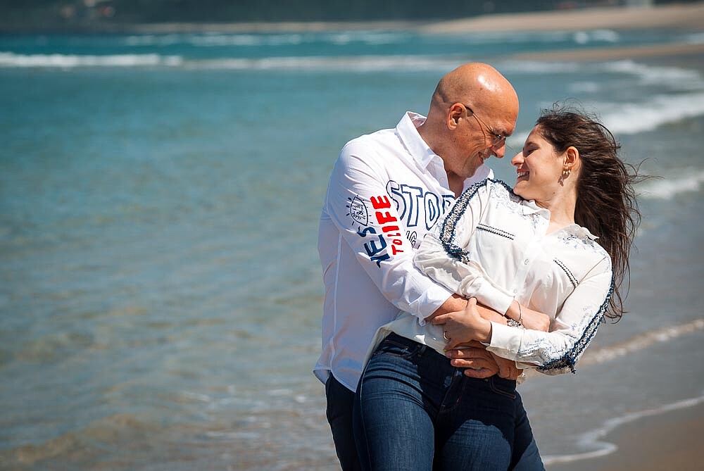 Noivo a abraçar por trás a Noiva e a olharem um para o outro