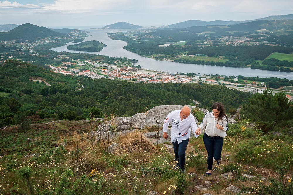Casal a caminhar pela a montanha de mãos dadas