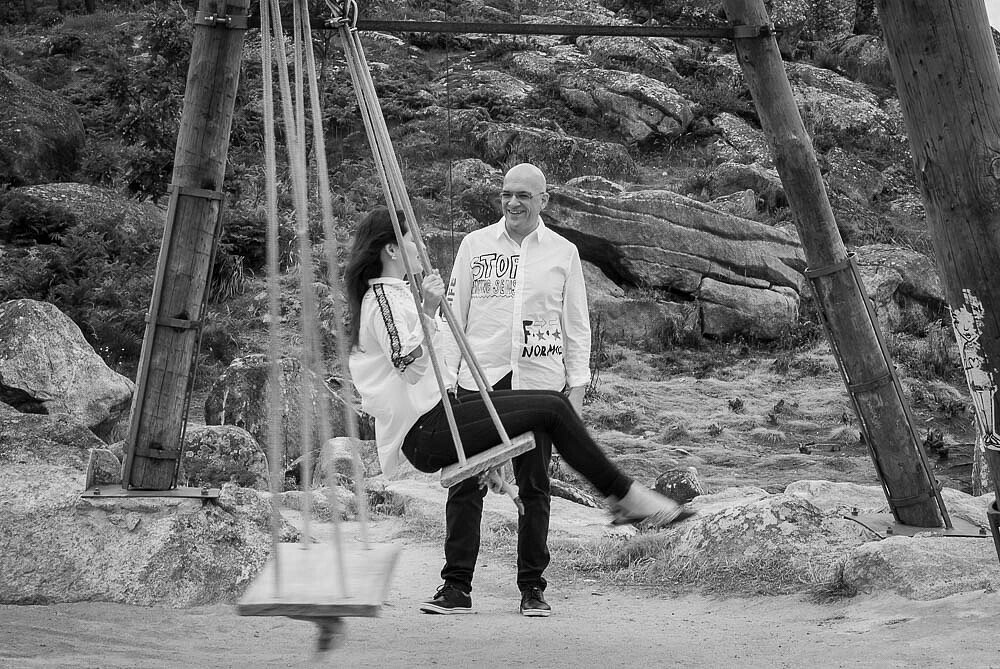 Noivo de pé enquanto a Noiva está no baloiço 