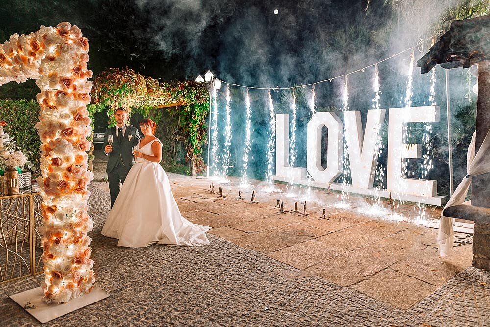 Casal a beira da placa a dizer "LOVE"