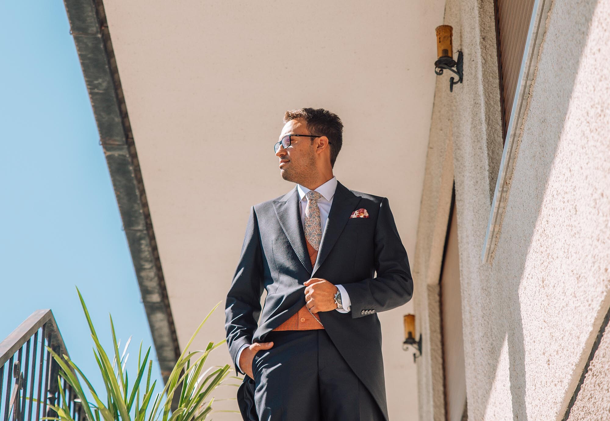 Noivo a olhar para o lado enquanto segura o fato