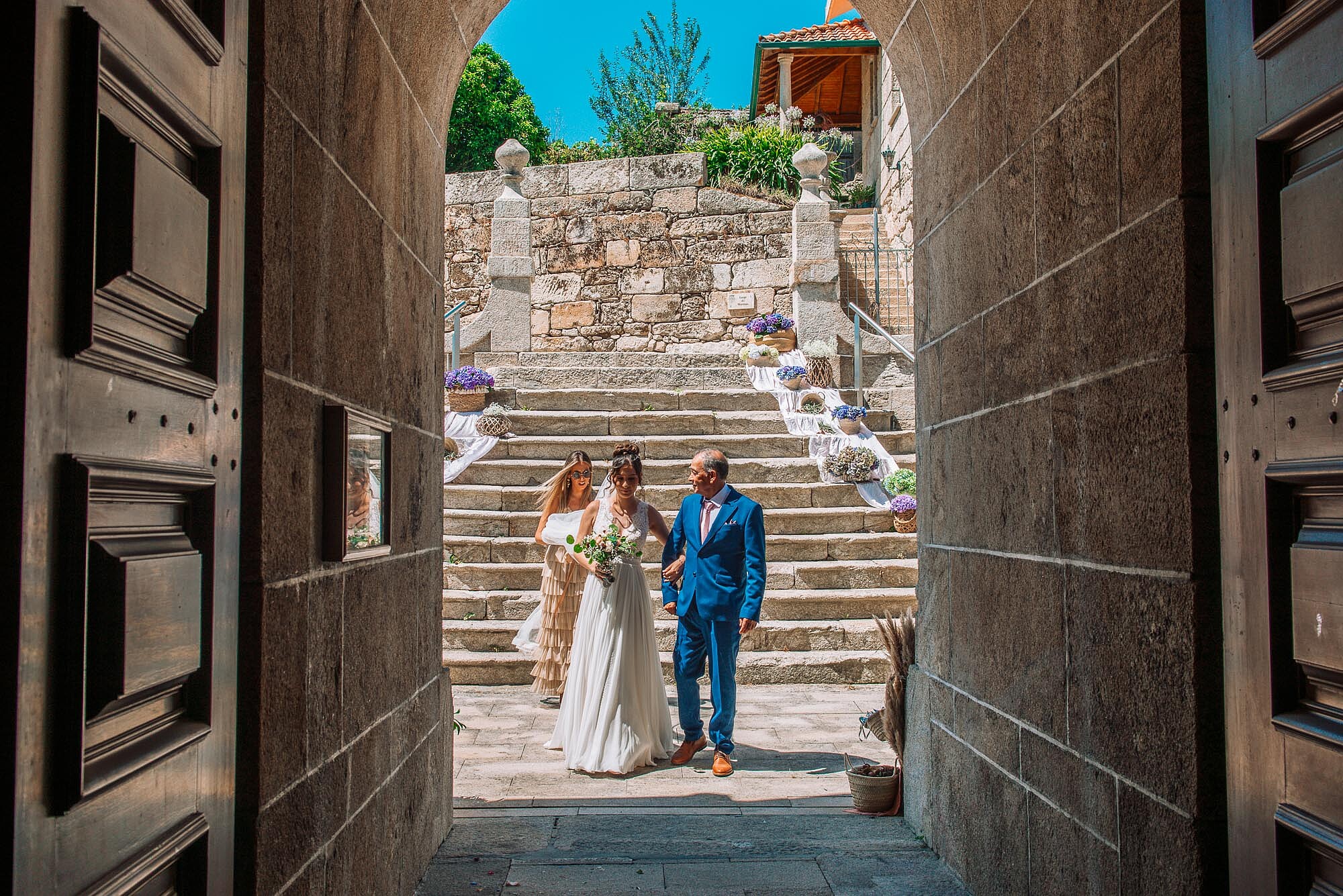 Noiva com os pais a entrada da igreja