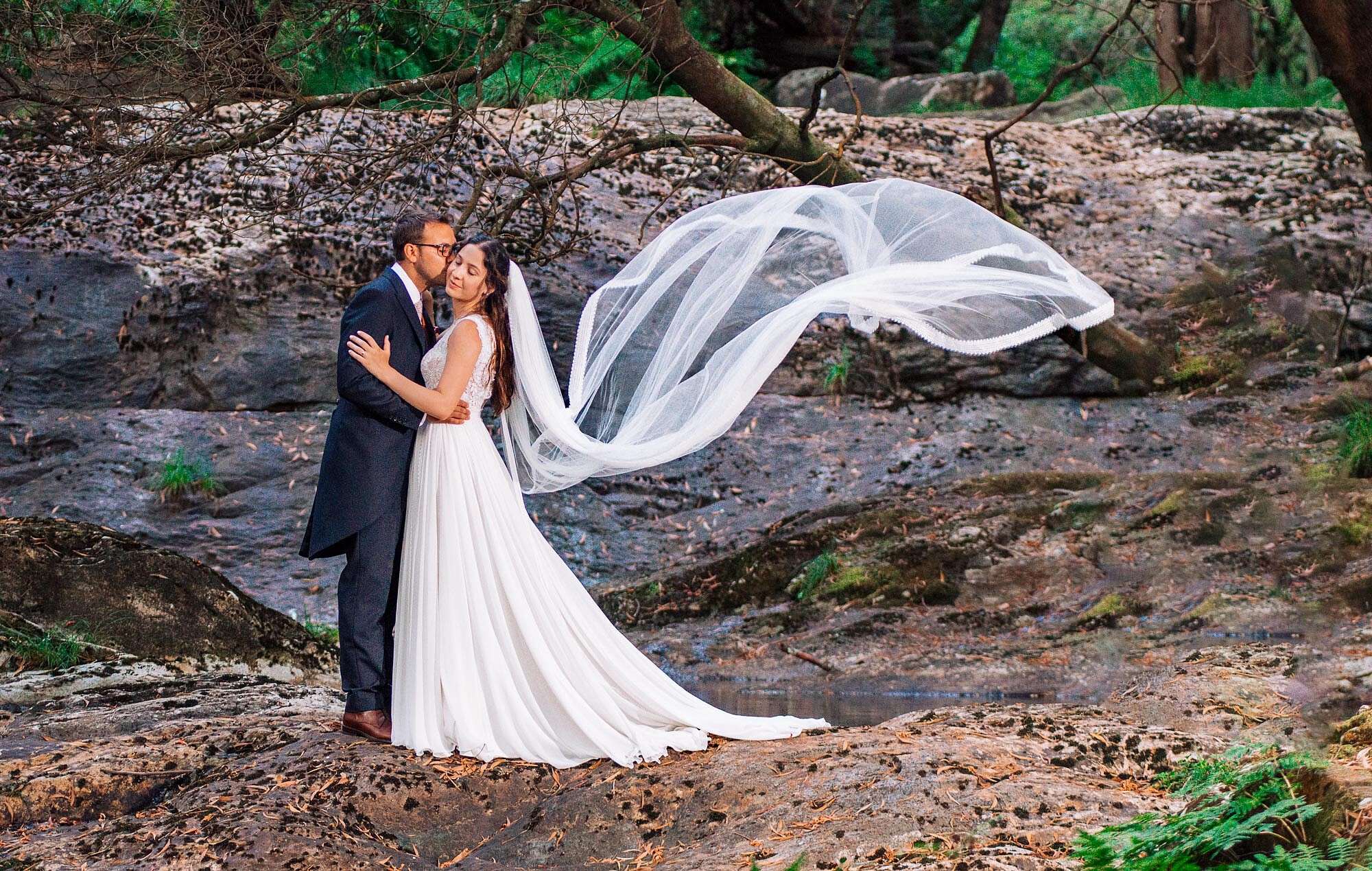 Pós Casamento: Homem a dar beijo na bochecha da Esposa enquanto o véu dela flutua