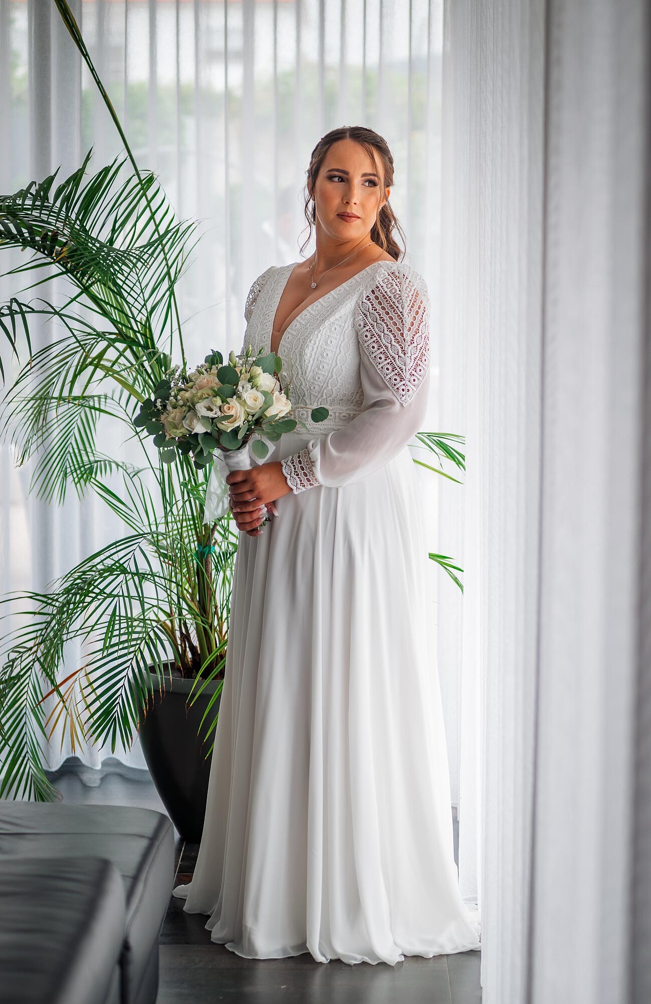 Noiva a olhar para o lado e a segurar o buque