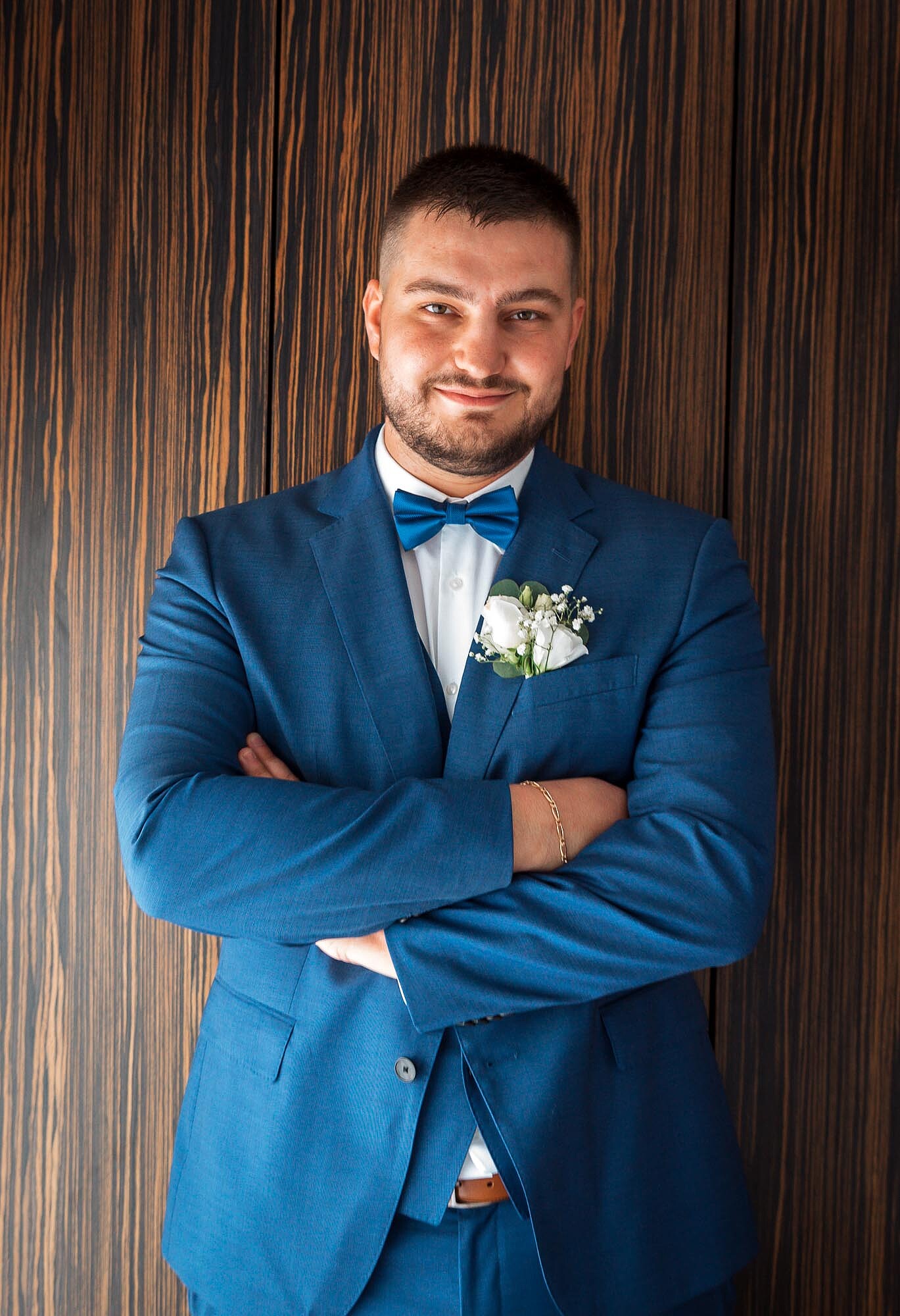 Noivo a sorrir e de braços cruzados