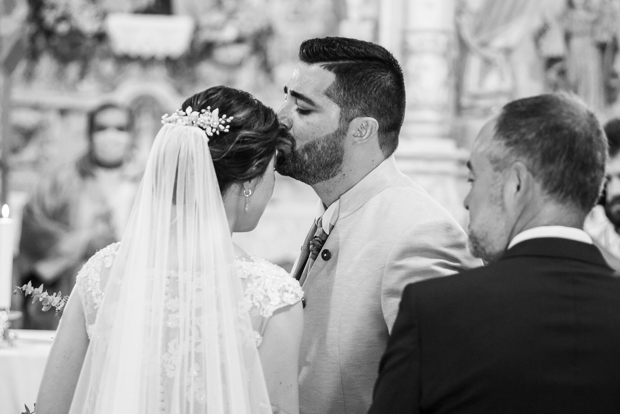 Noivo a beijar a testa da Noiva