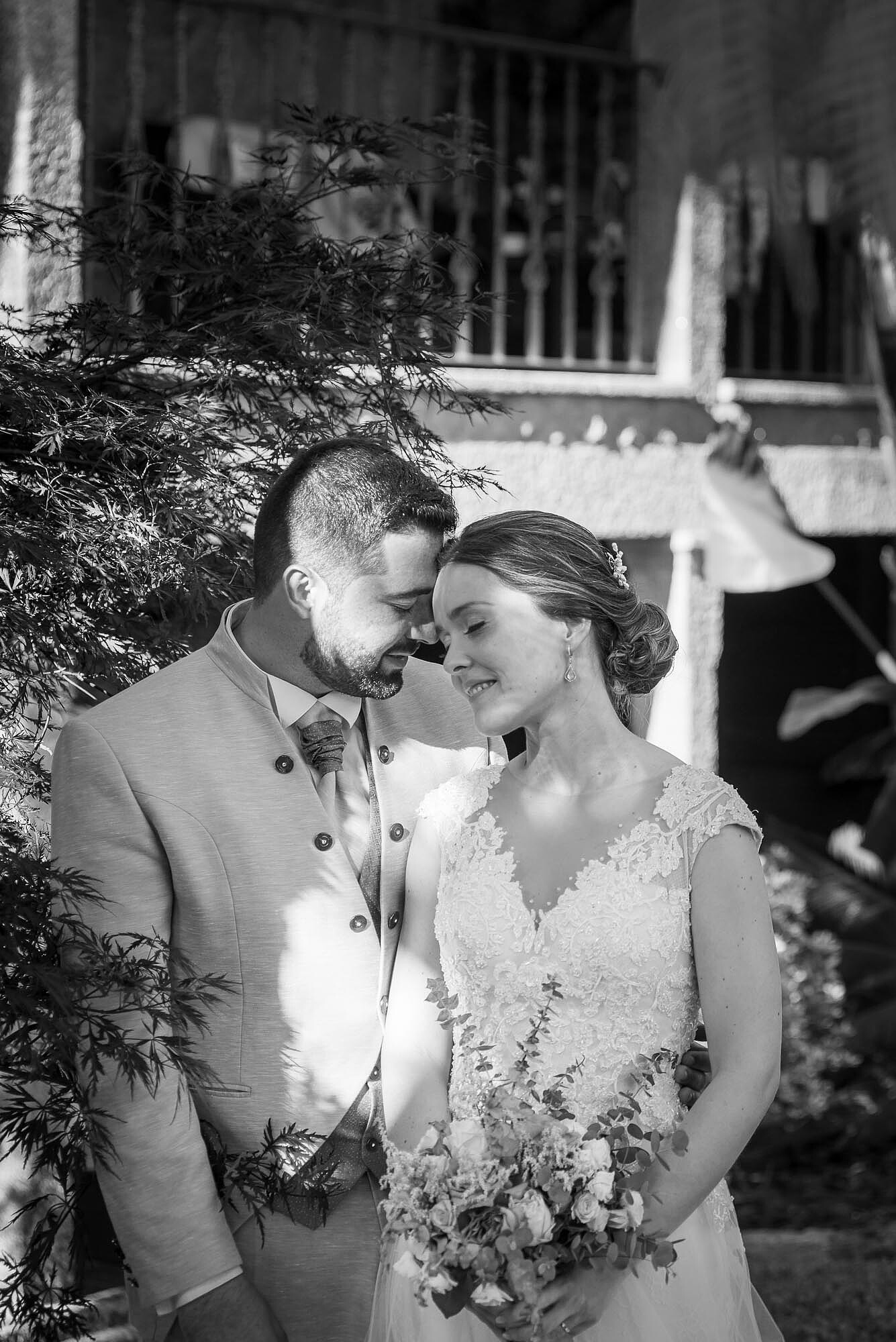 Casal no jardim com a cabeça encostada uma na outra