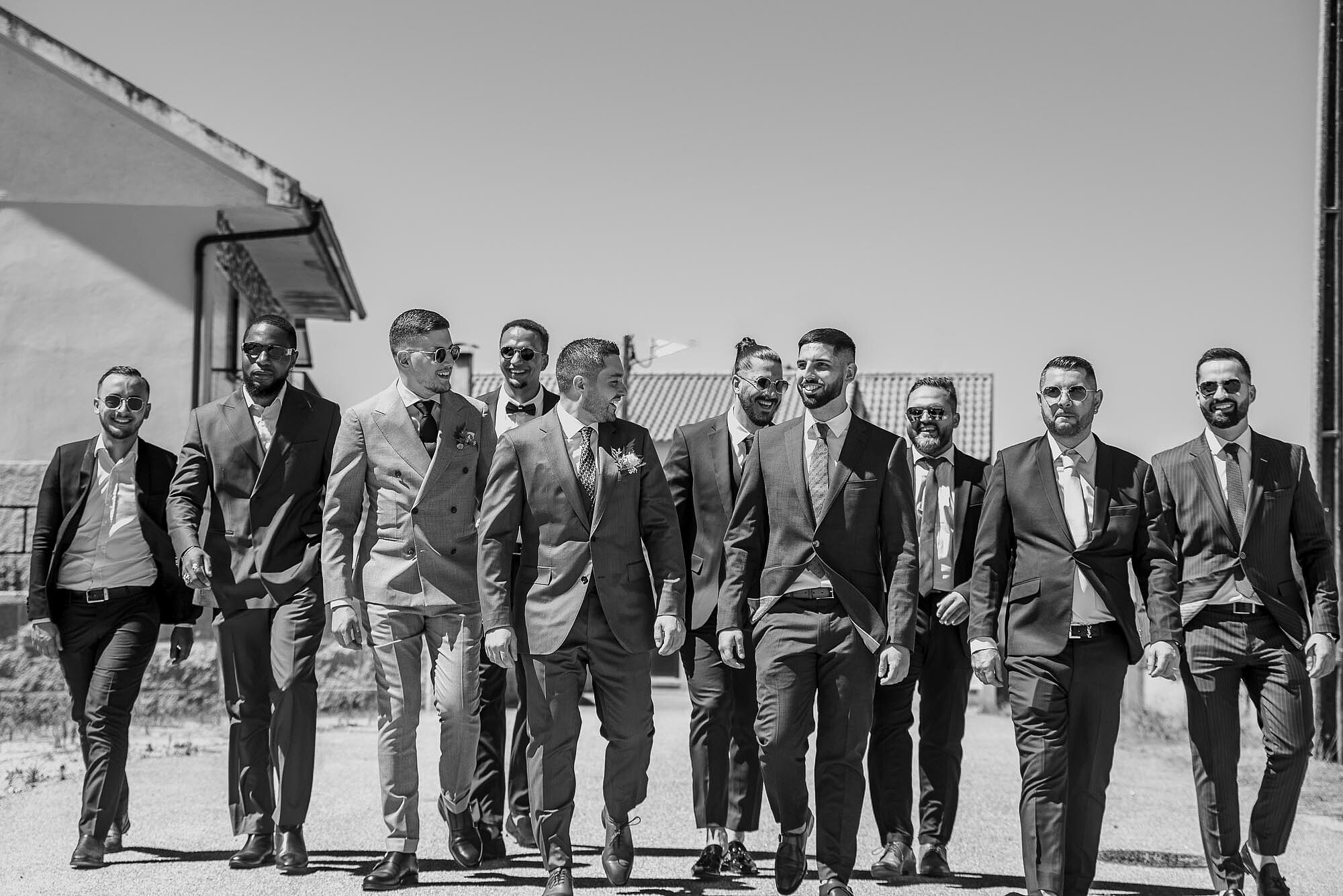 Noivo a caminhar com os padrinhos