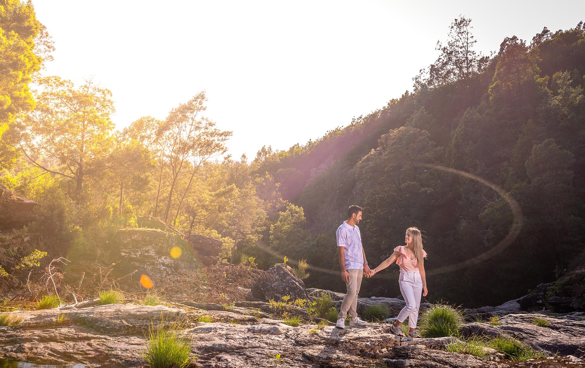 Casal a caminhar pela a montanha de mãos dadas