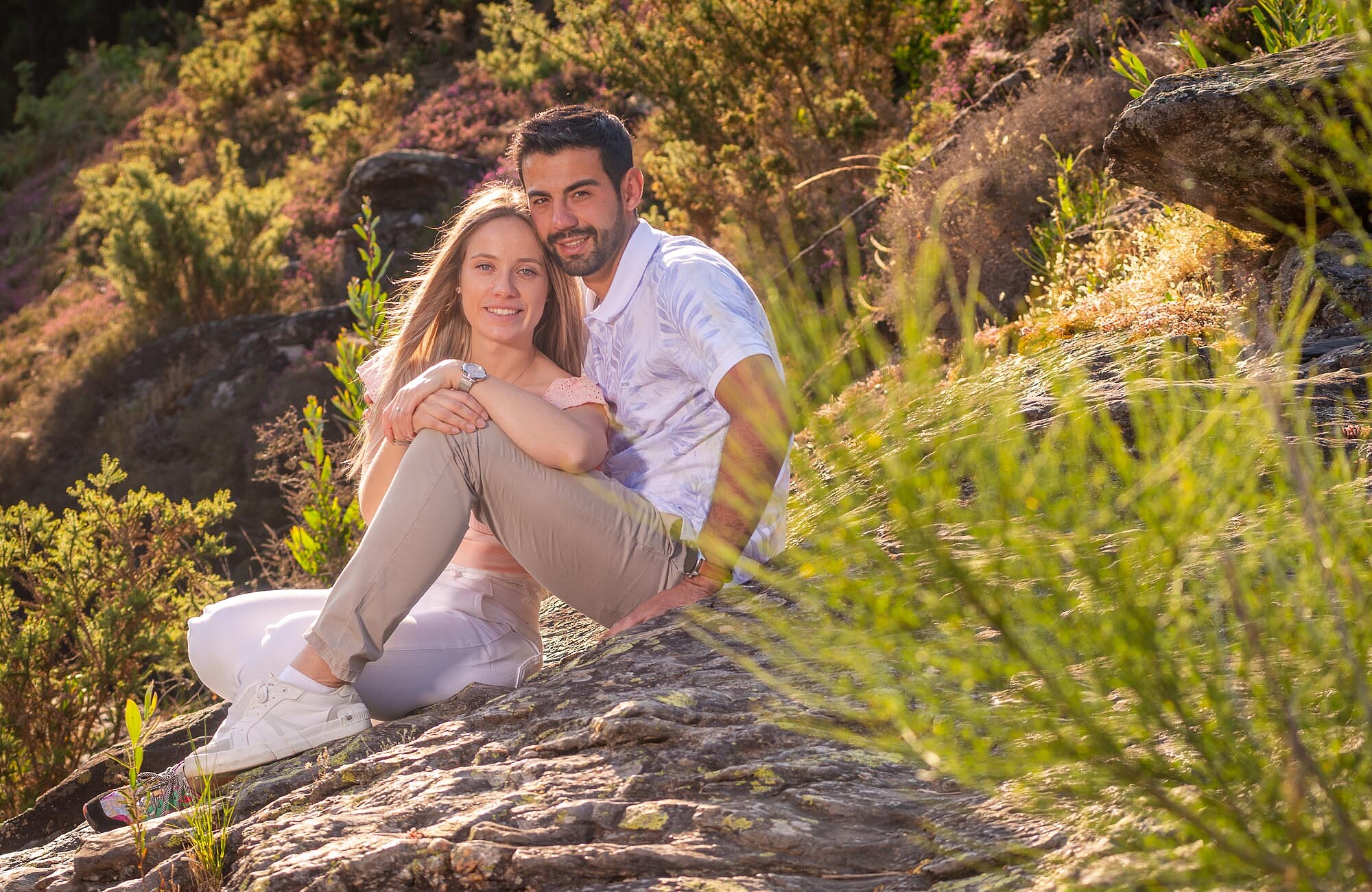 Casal sentado nas pedras juntos um ao outro