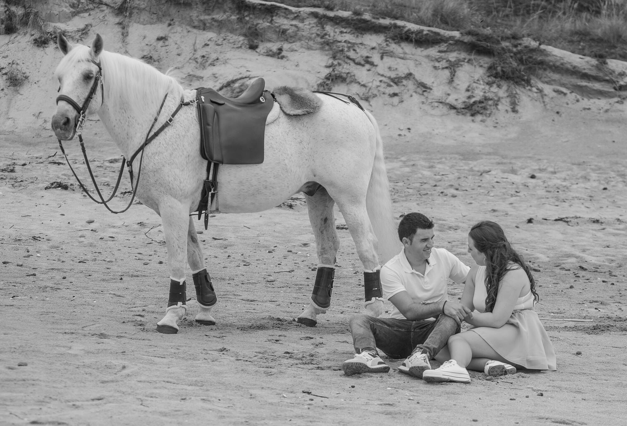 Casal sentados na areia a conversar 