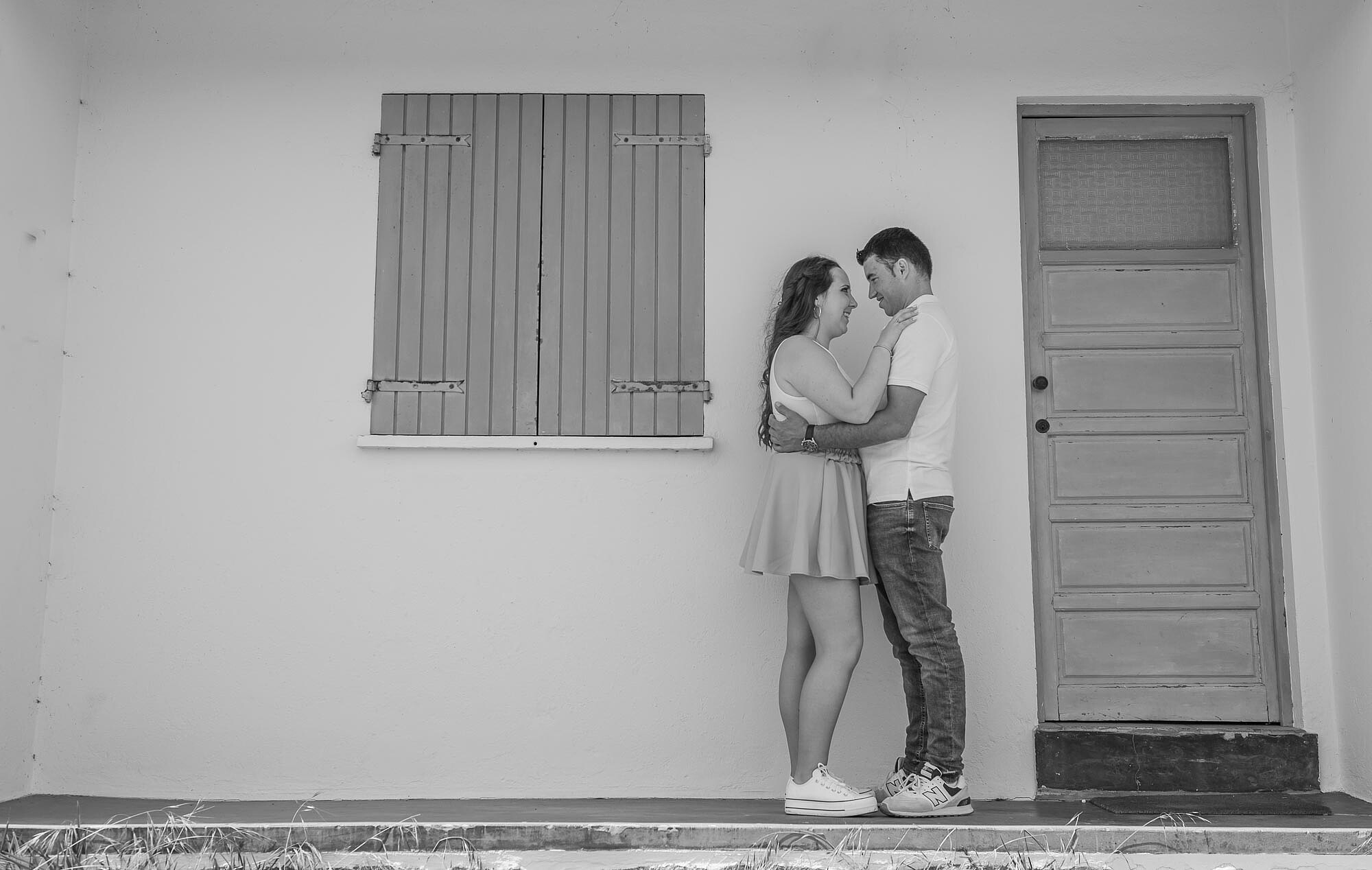 Casal a olhar um para o outro apaixonadamente a porta de casa