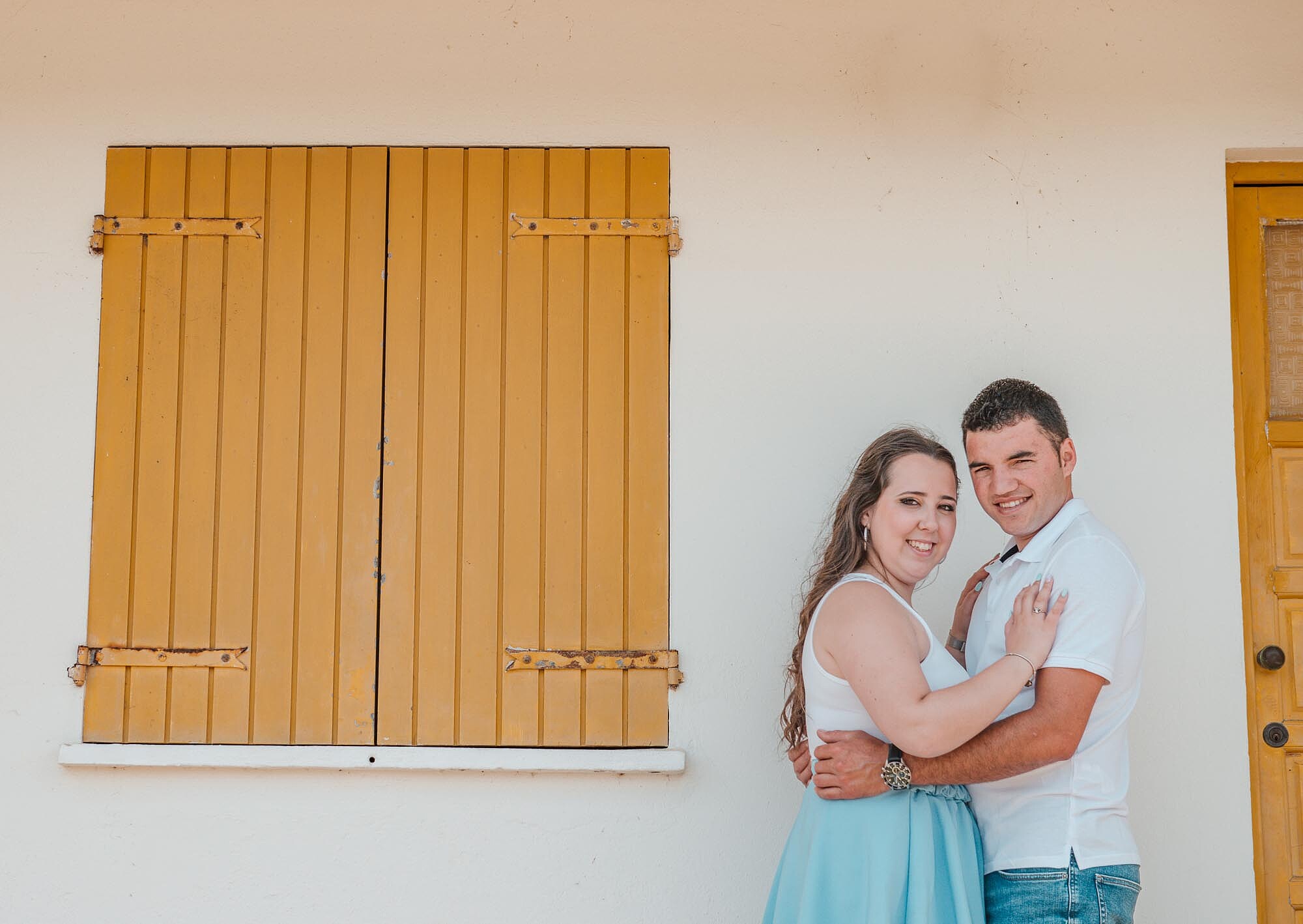 Casal a porta de casa a fazer pose