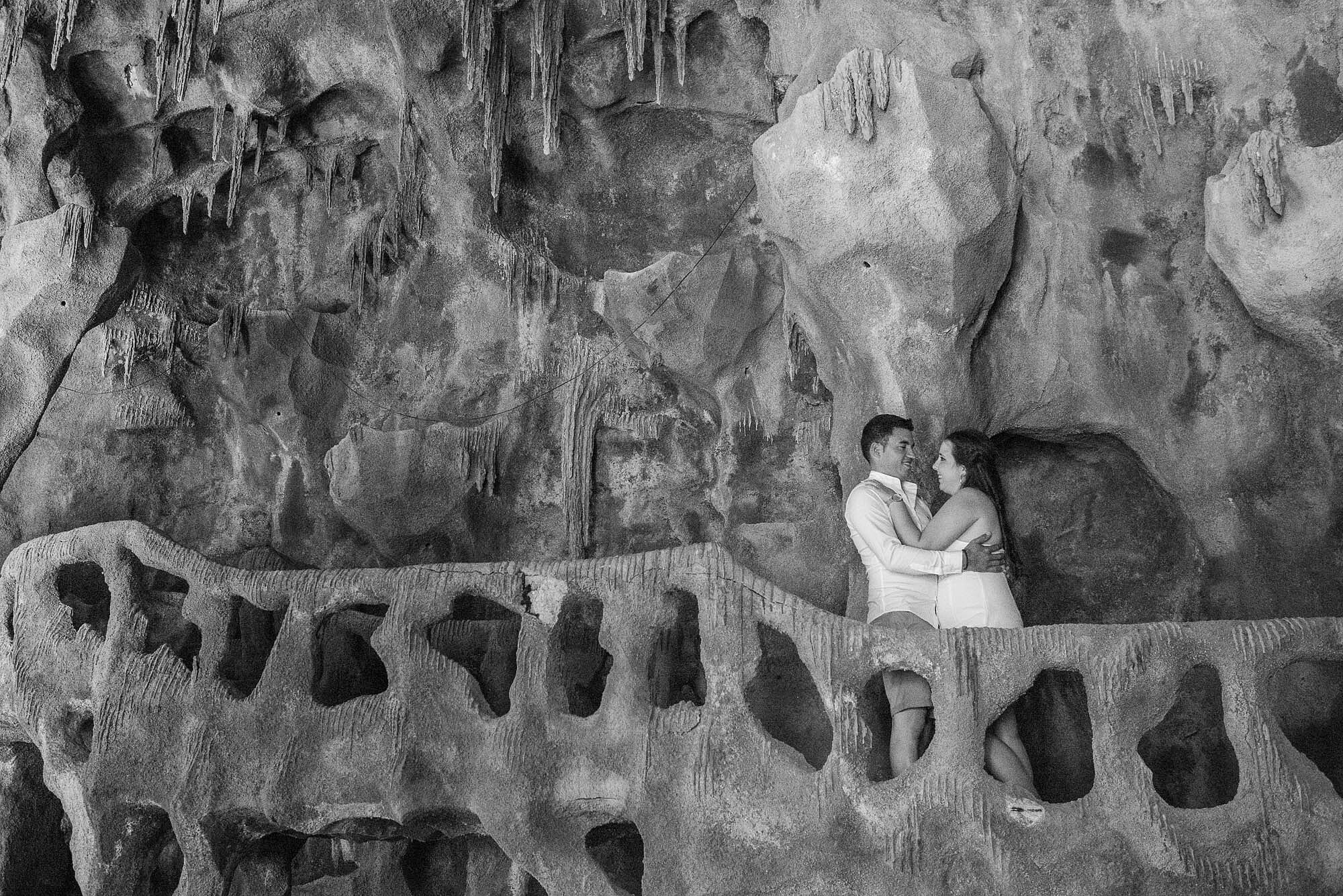Casal a dar um abra&ccedil;o dentro de uma caverna