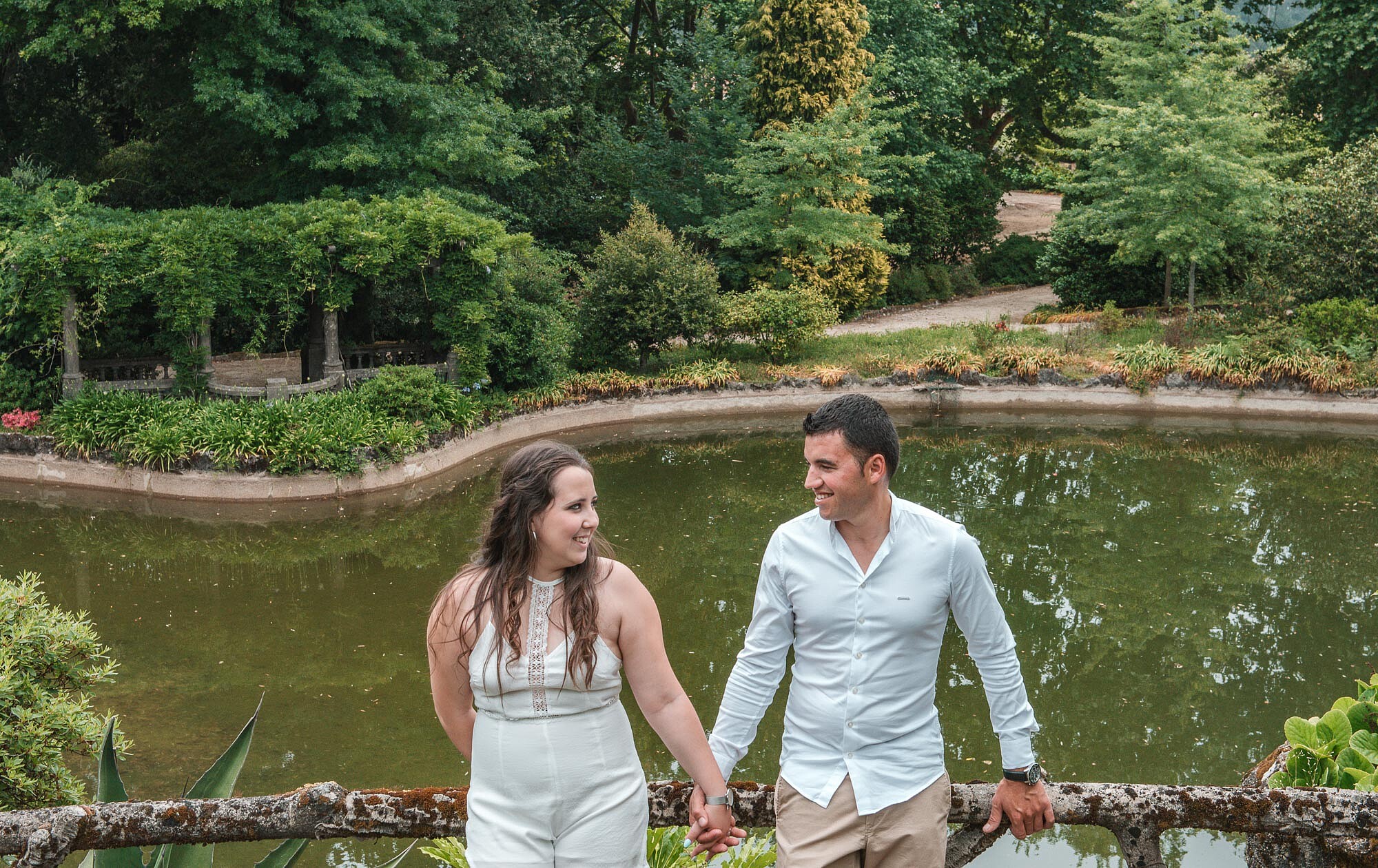 Casal de m&atilde;os dadas a beira do lago