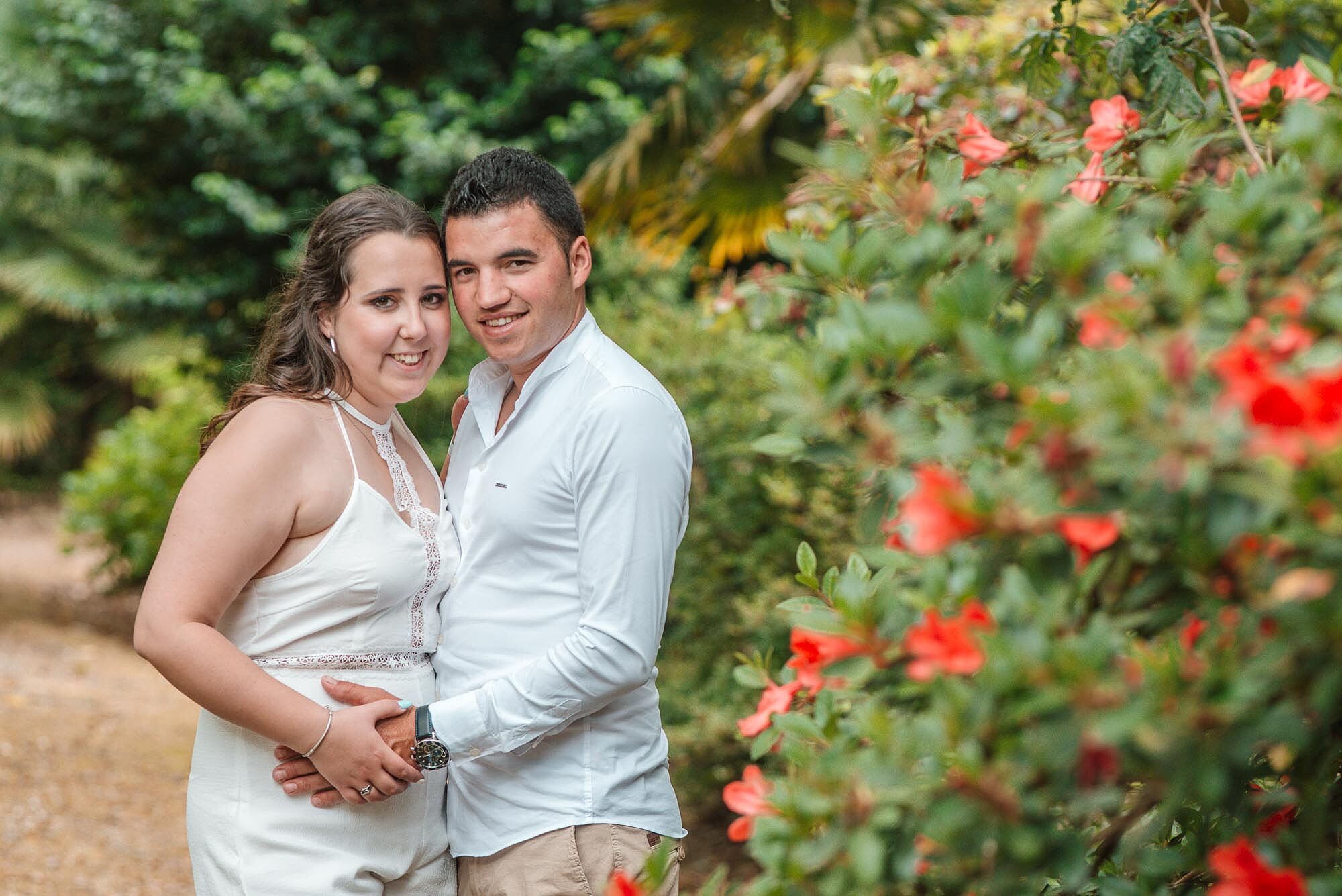 Casal a dar um abra&ccedil;o a beira de um arbusto 