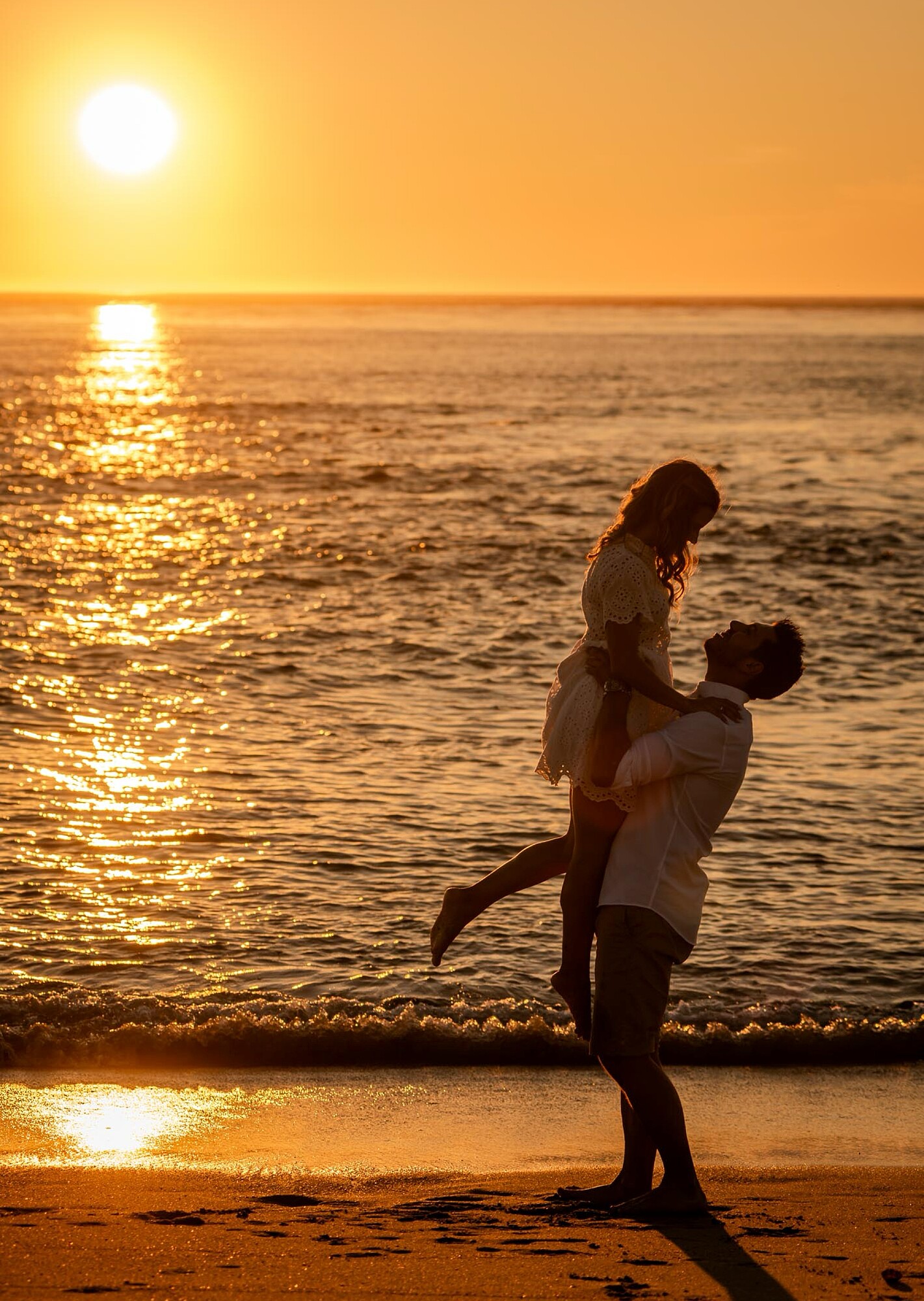 Por do Sol enquanto o Homem pega a namorada ao colo