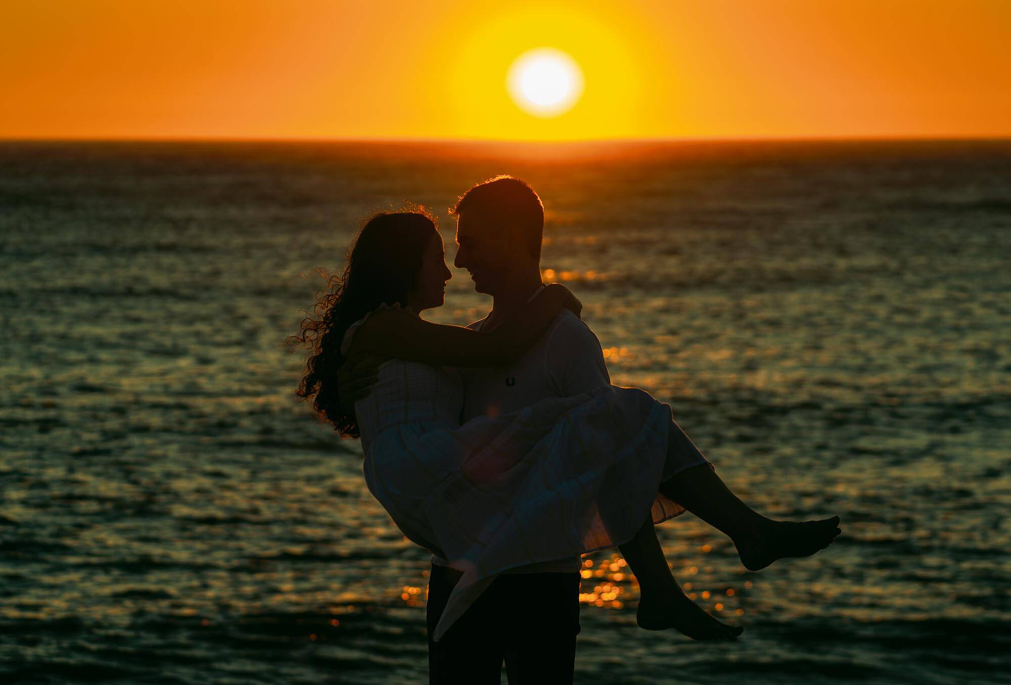 namorados em silhueta ao por do sol