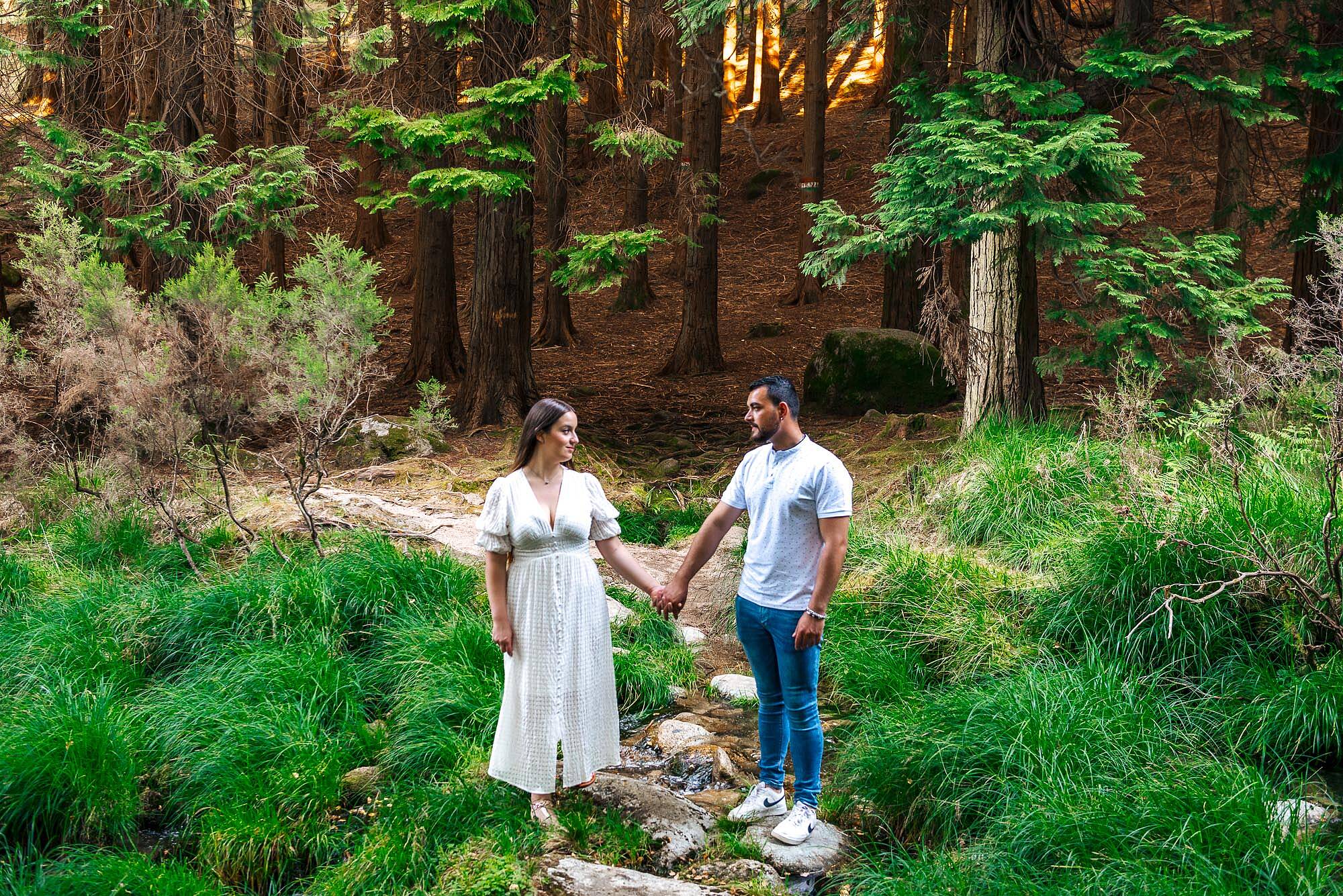 CASAL DE NAMORADOS DE MÃOS DADAS EM CIMA DAS PEDRAS