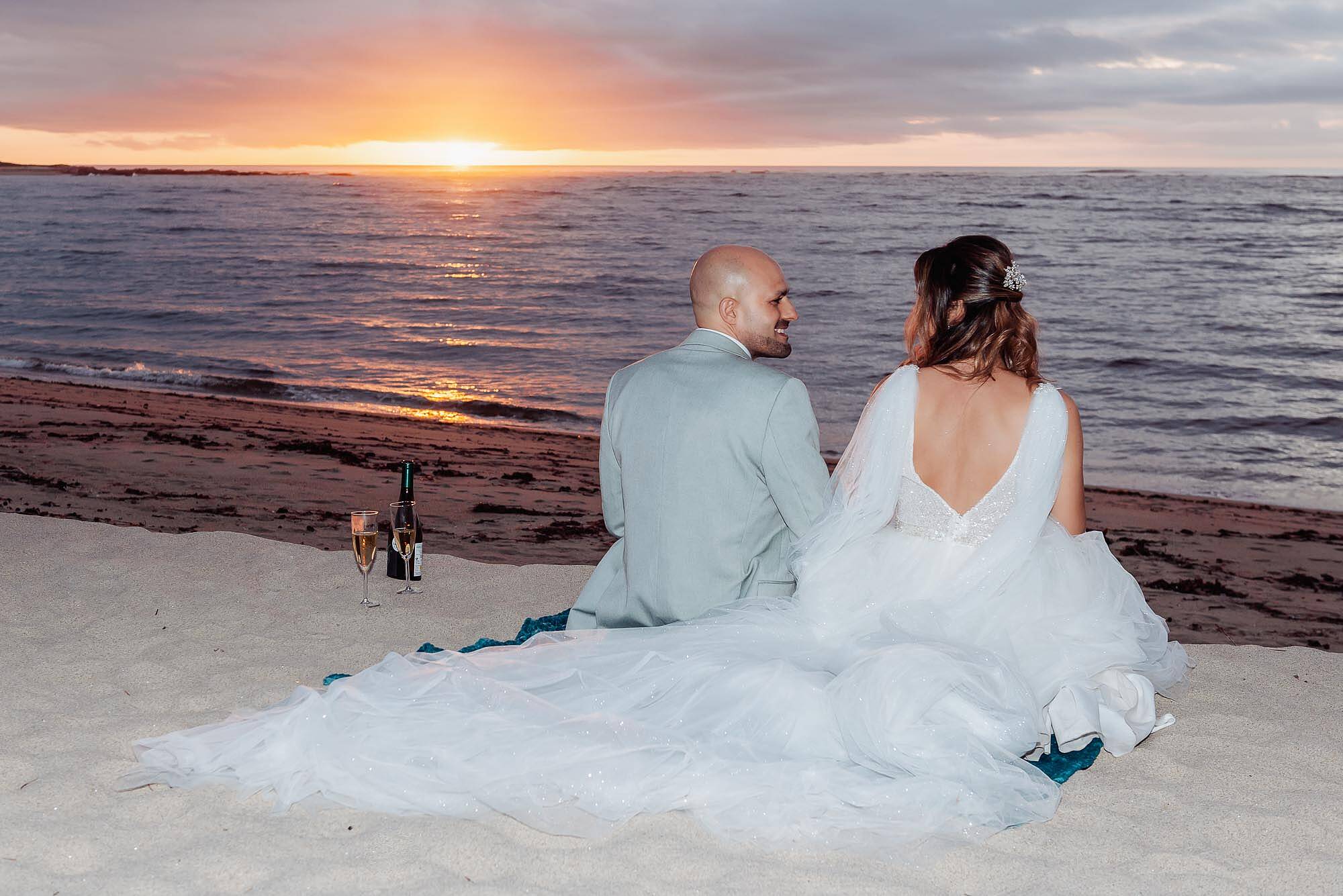 noivos sentados ao por do sol
