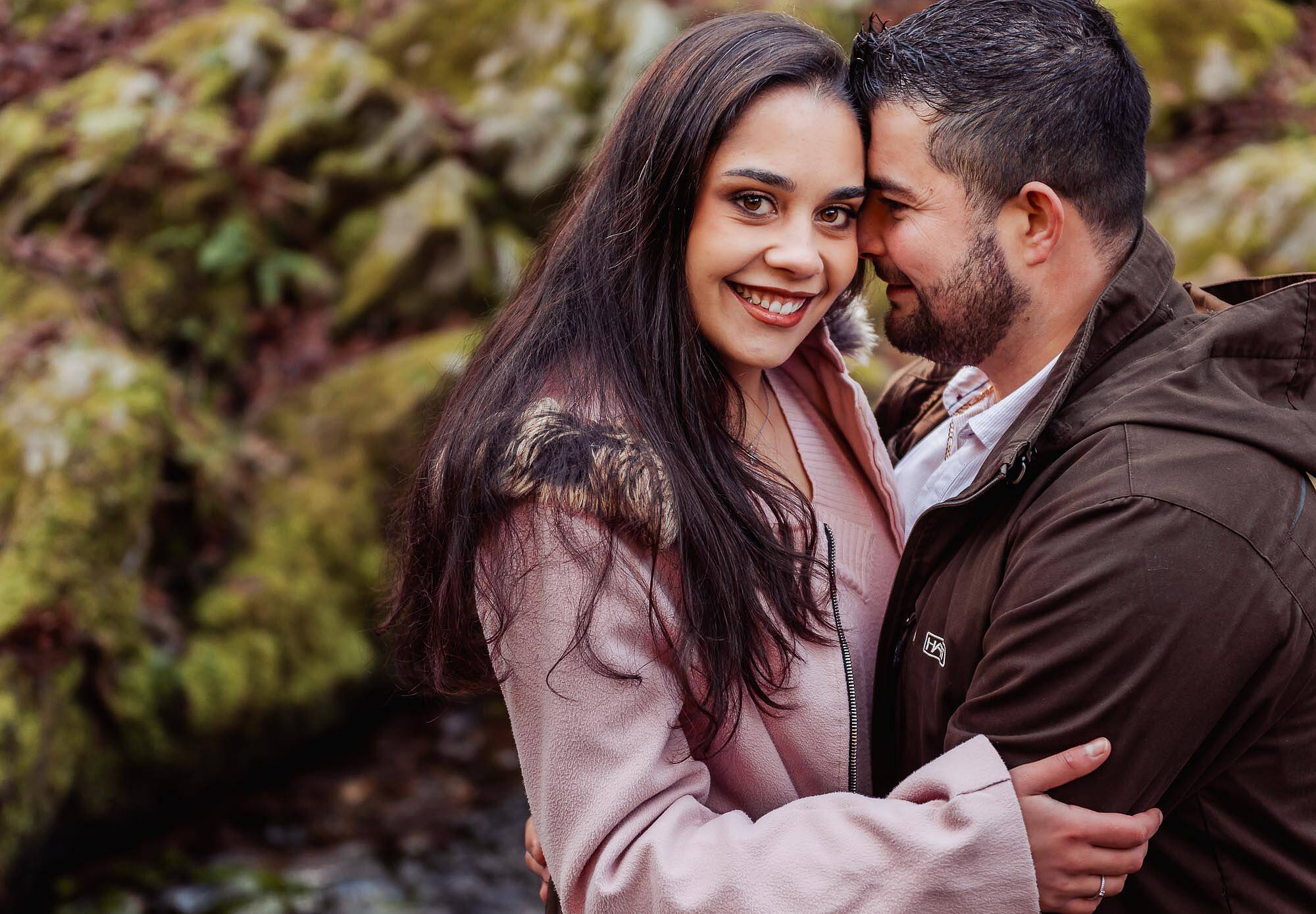namorado a abraçar enquanto namorada olha na máquina fotografica