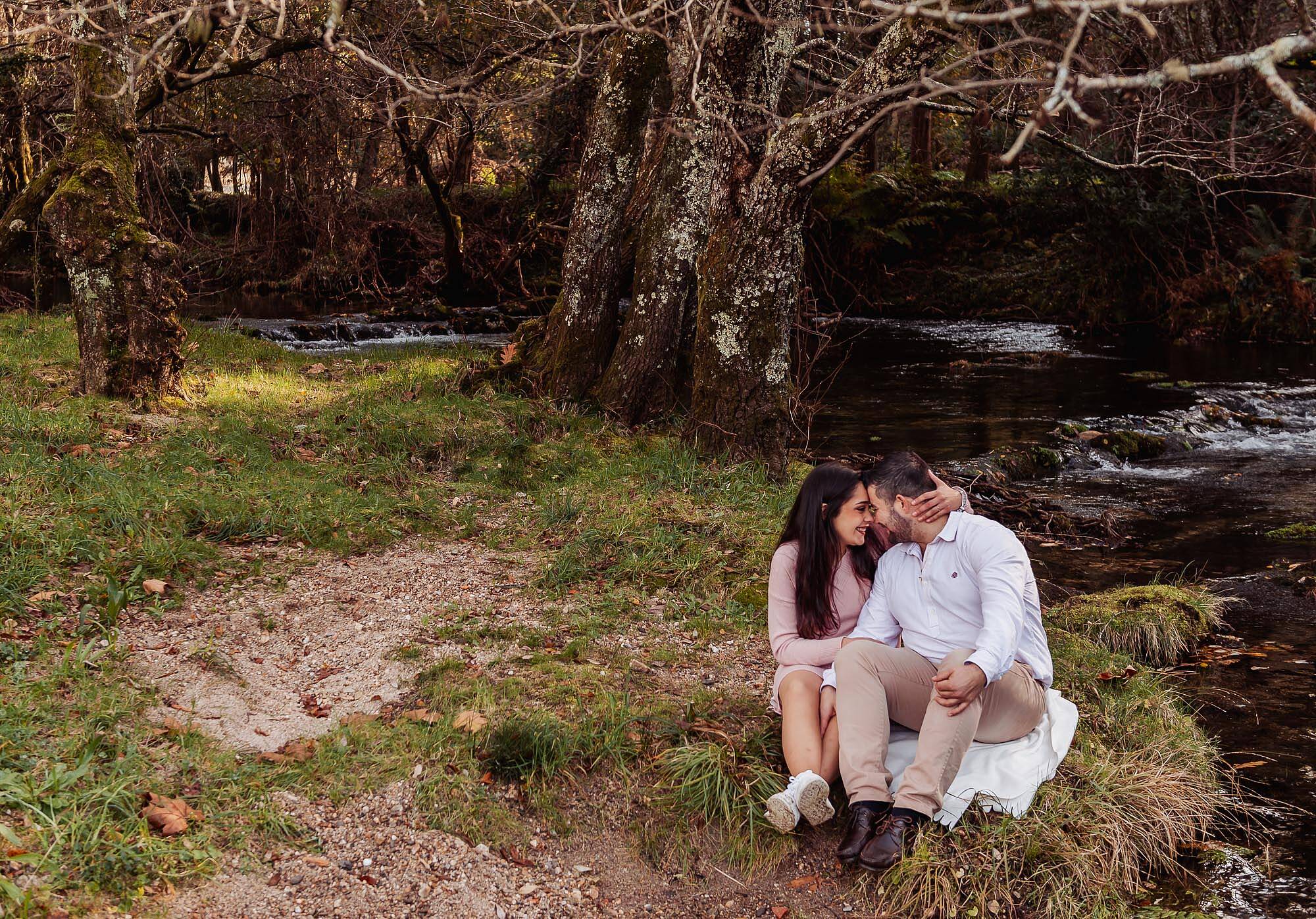 namorados sentados junto ao rio