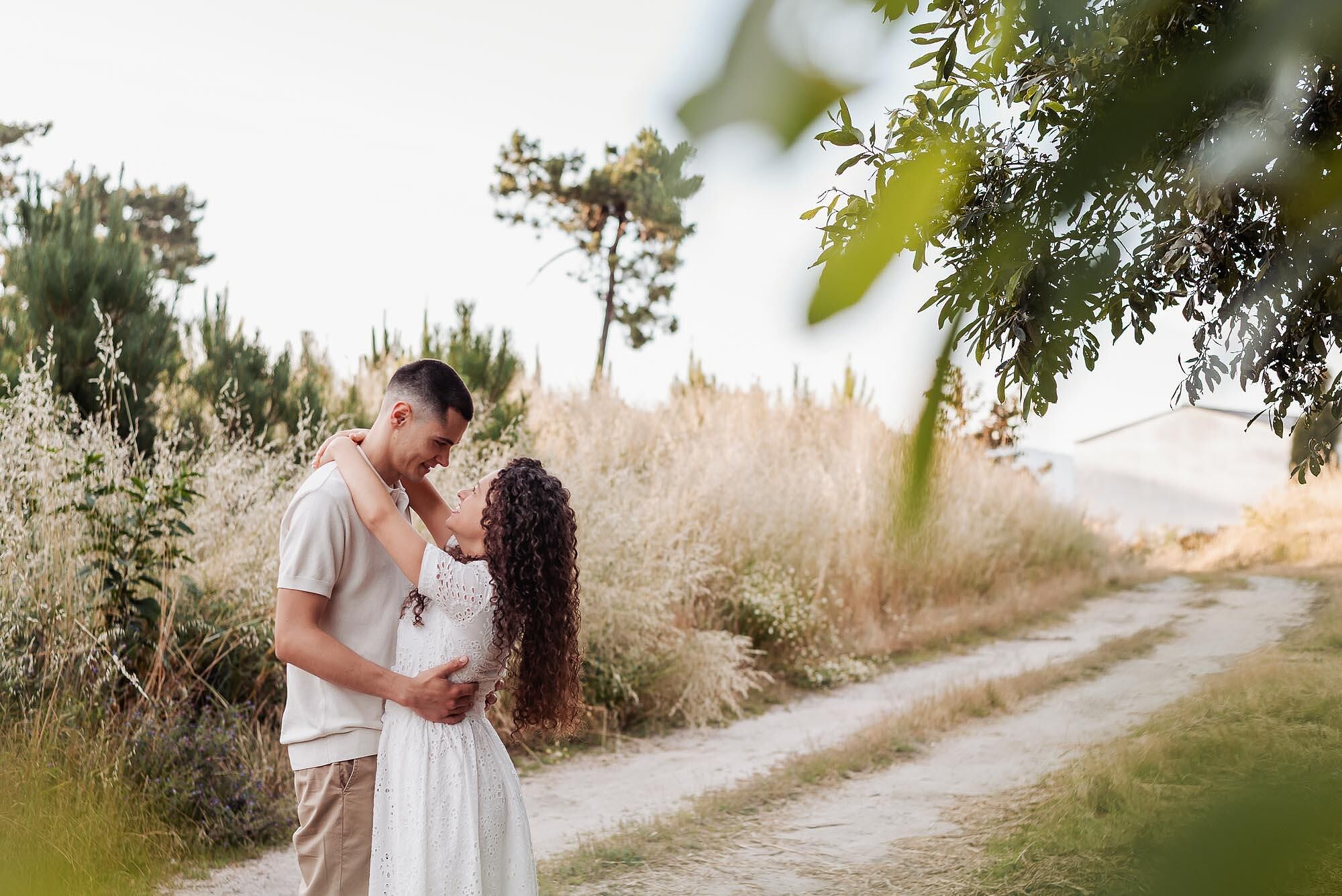 casal a abracarse num caminho rodeado de natureza