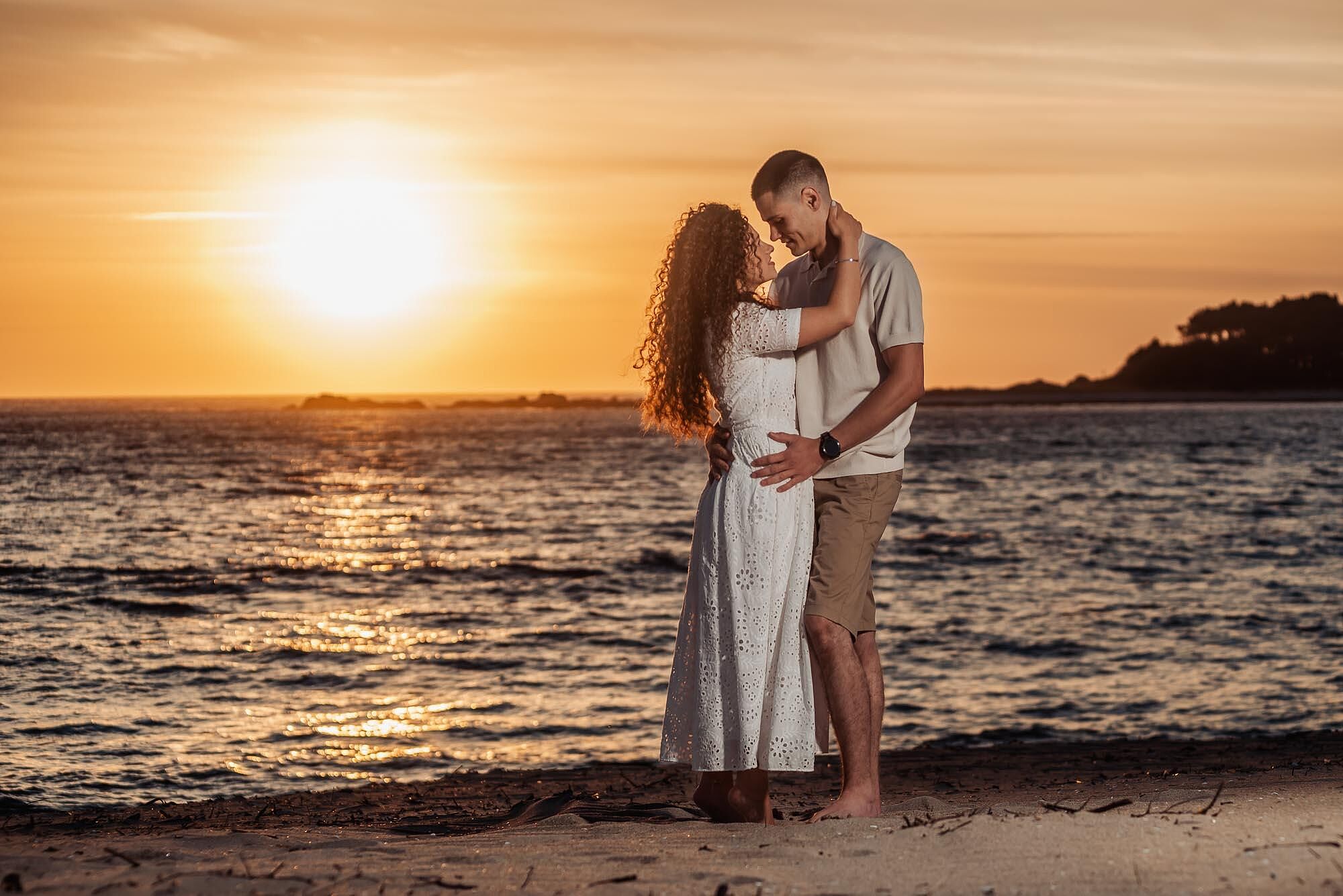 casal abracado na praia ao pôr do sol