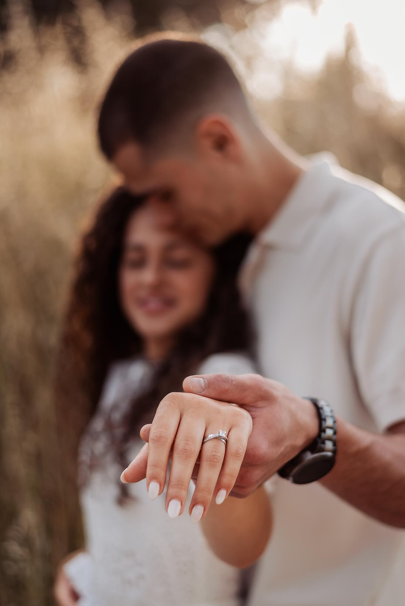 casal mostra a mao com anel de noivado em destaque