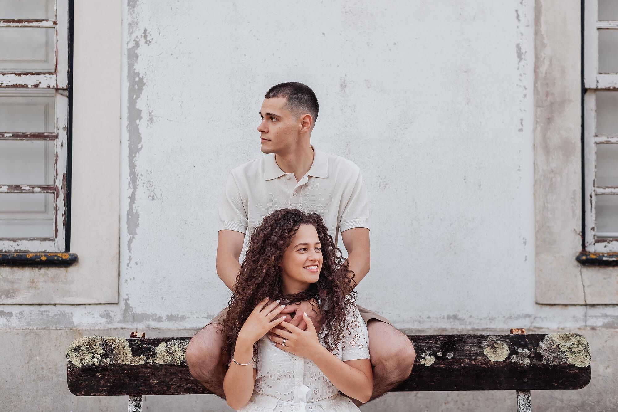 homem sentado atras da mulher com maos sobre os ombros dela