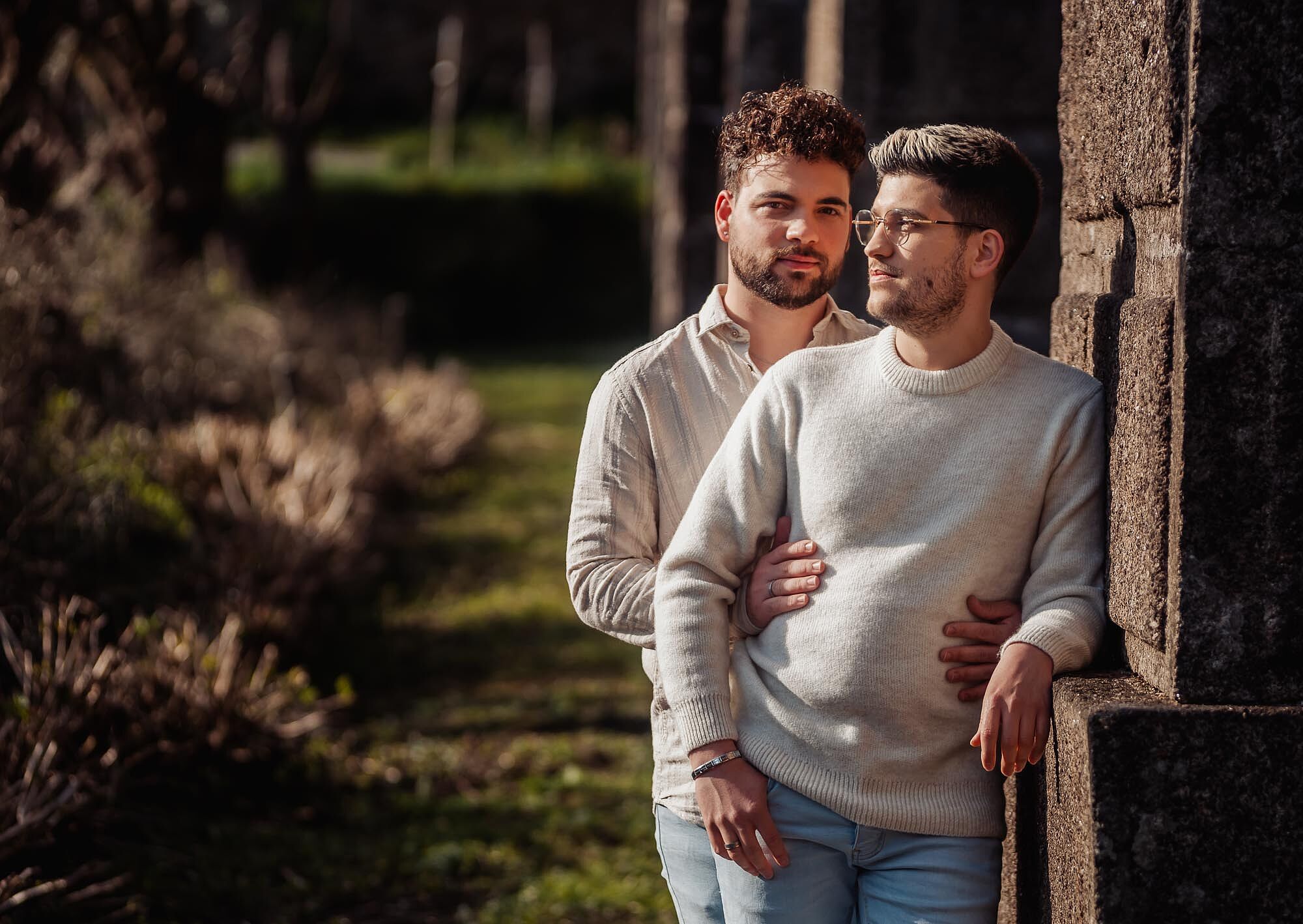 junto a pilar da ponte, um a olhar na câmera outro a olhar sol