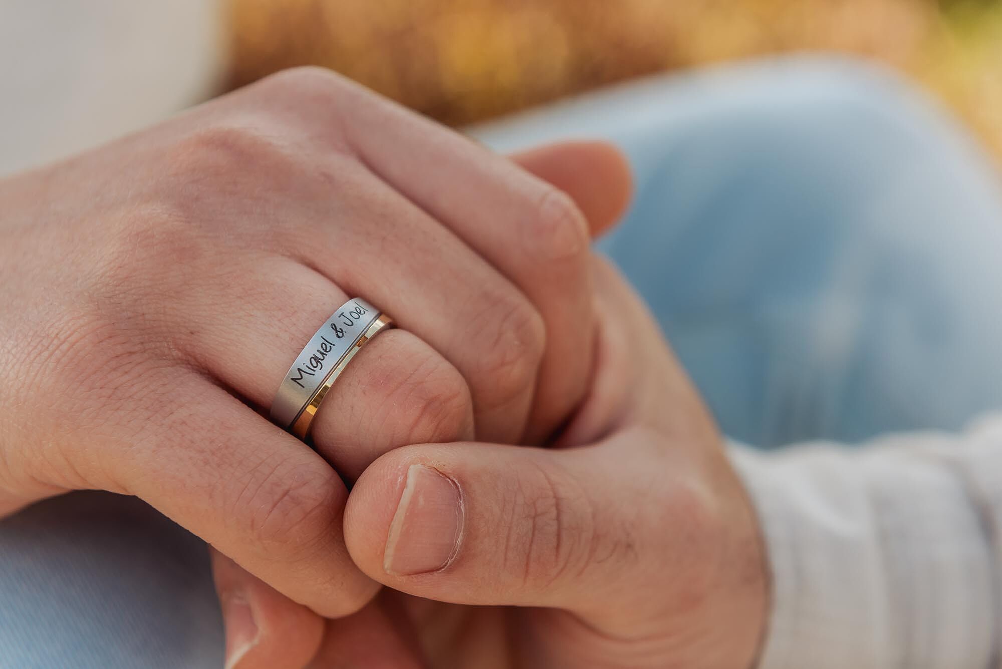 mãos com aliança de namorados e nomes deles