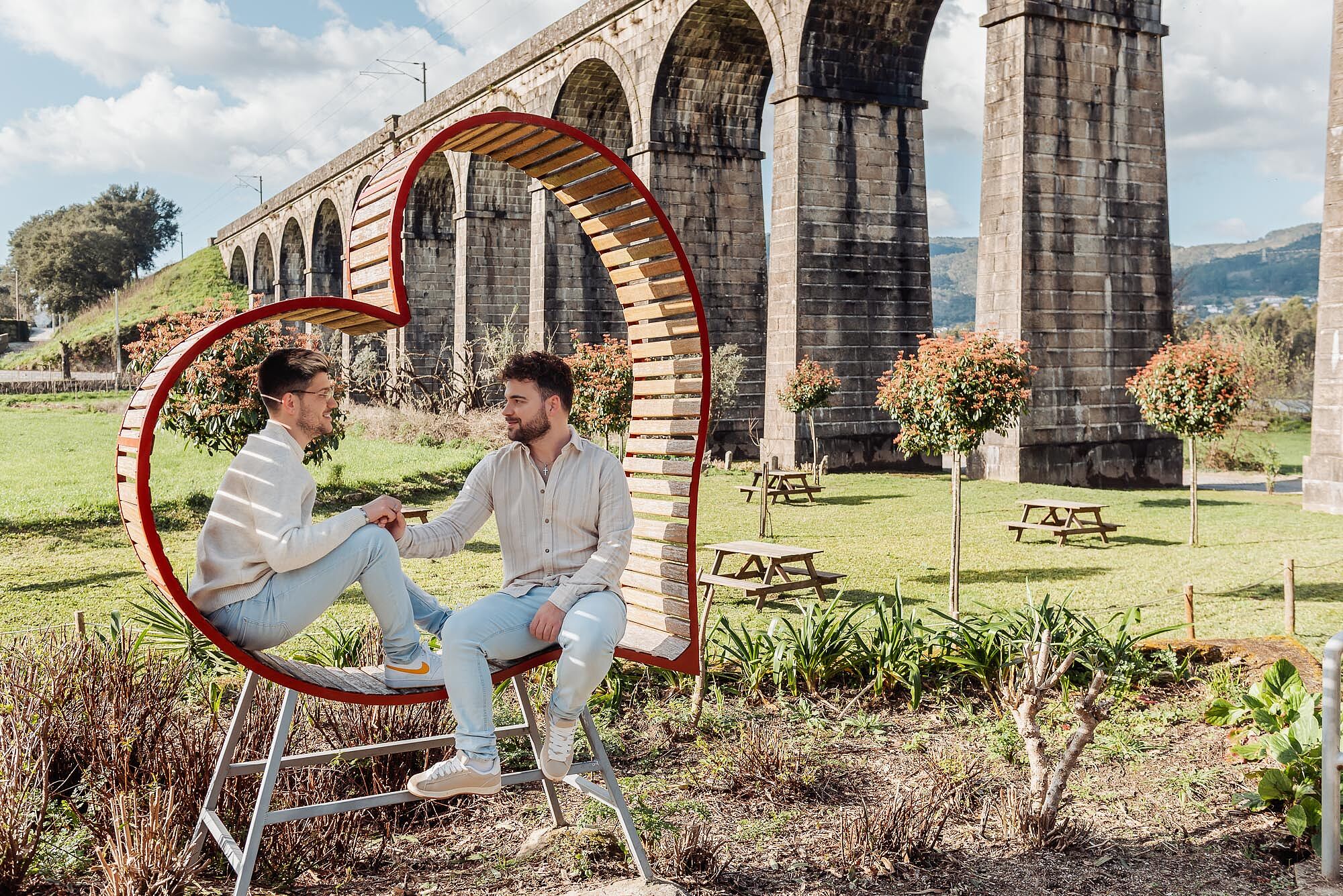 namorados no meio de coração de madeira junto a parque de merendas em balugães