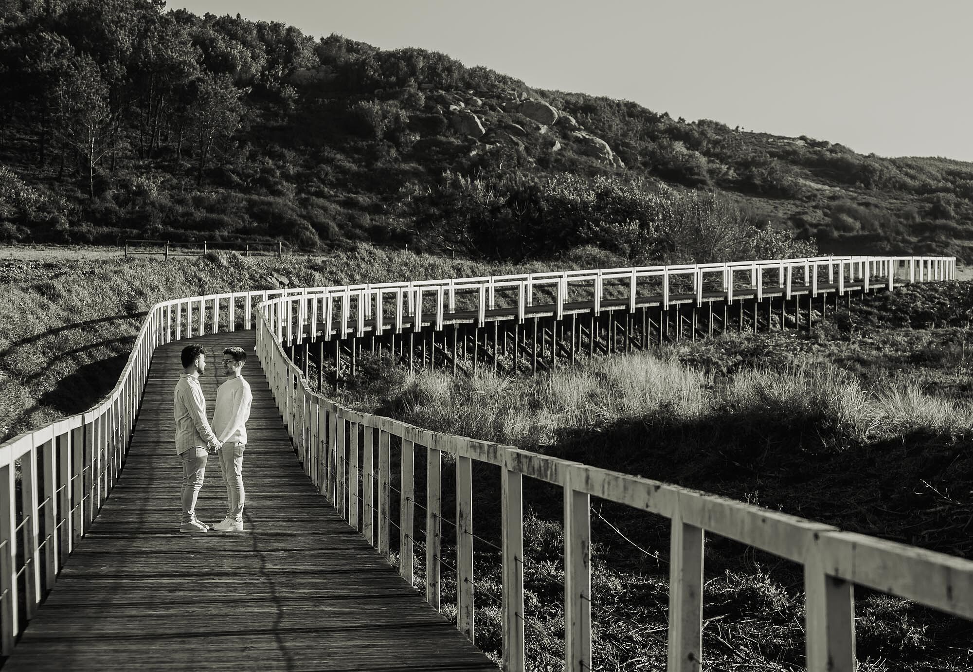 imagem a preto e branco de namorados em um passadiço que tem curvatura 