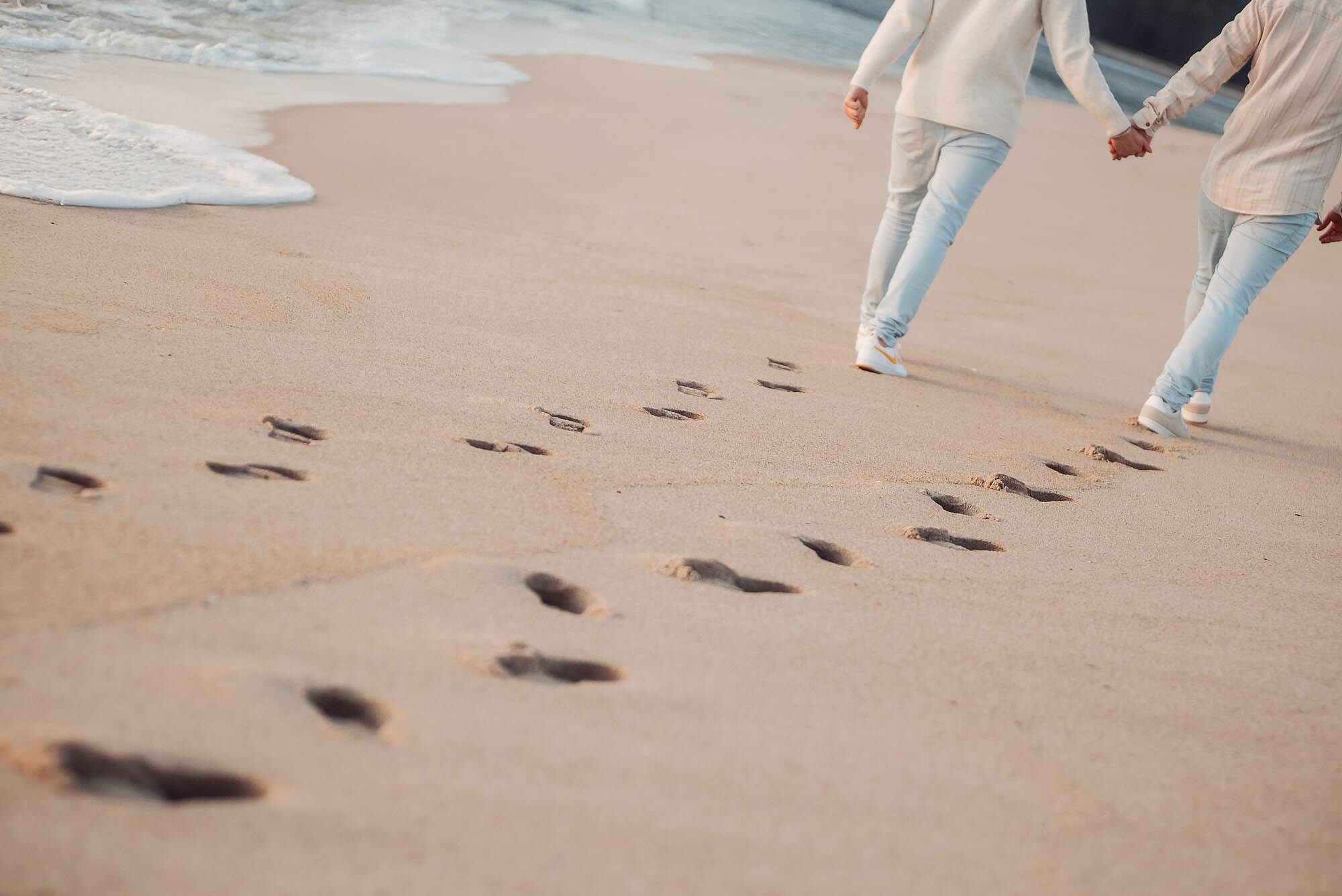 pegadas na areia de namorados a caminhar na praia da foz do minho