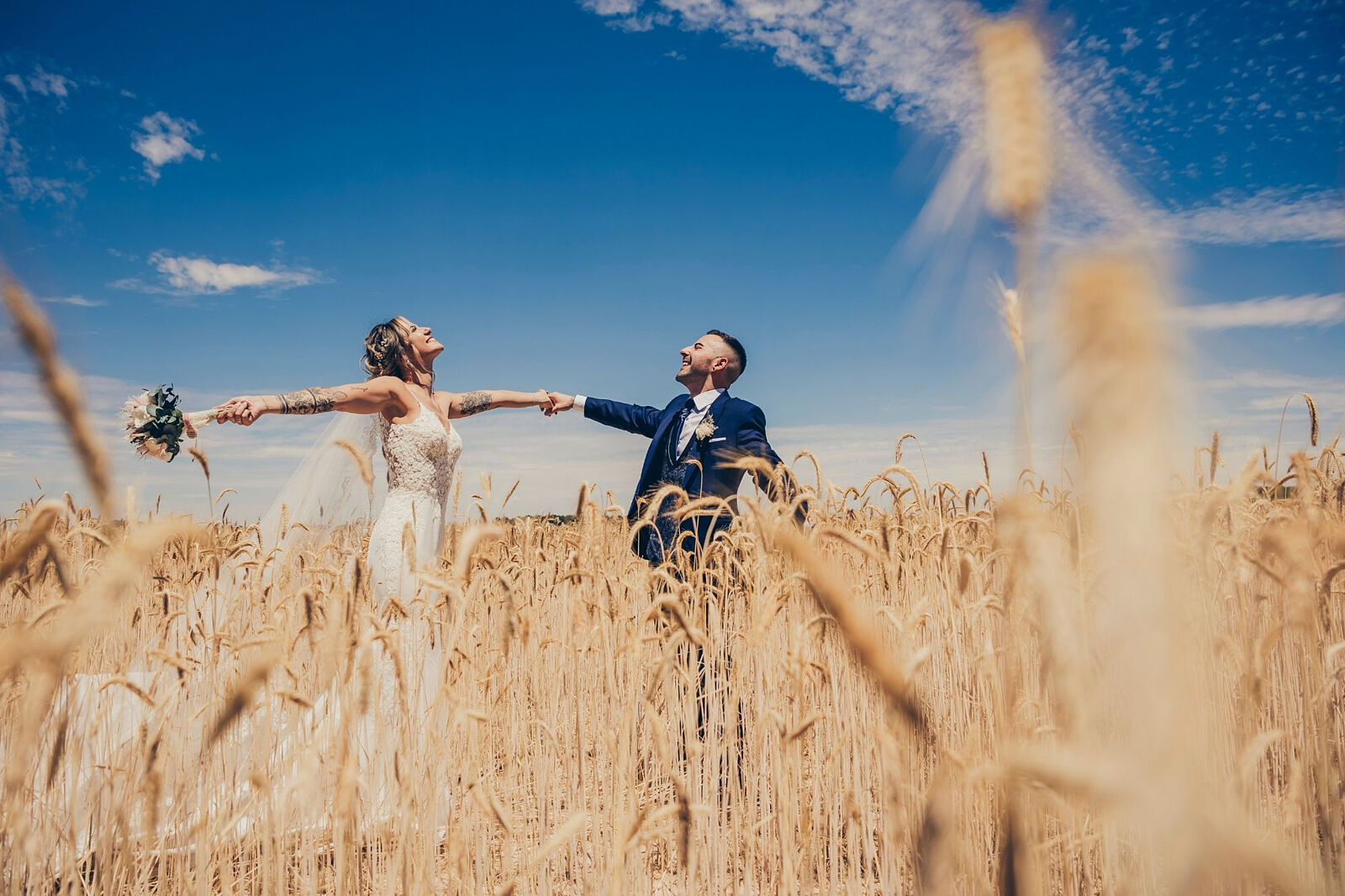 Novios en campo de trigo celebrando su boda en Valladolid