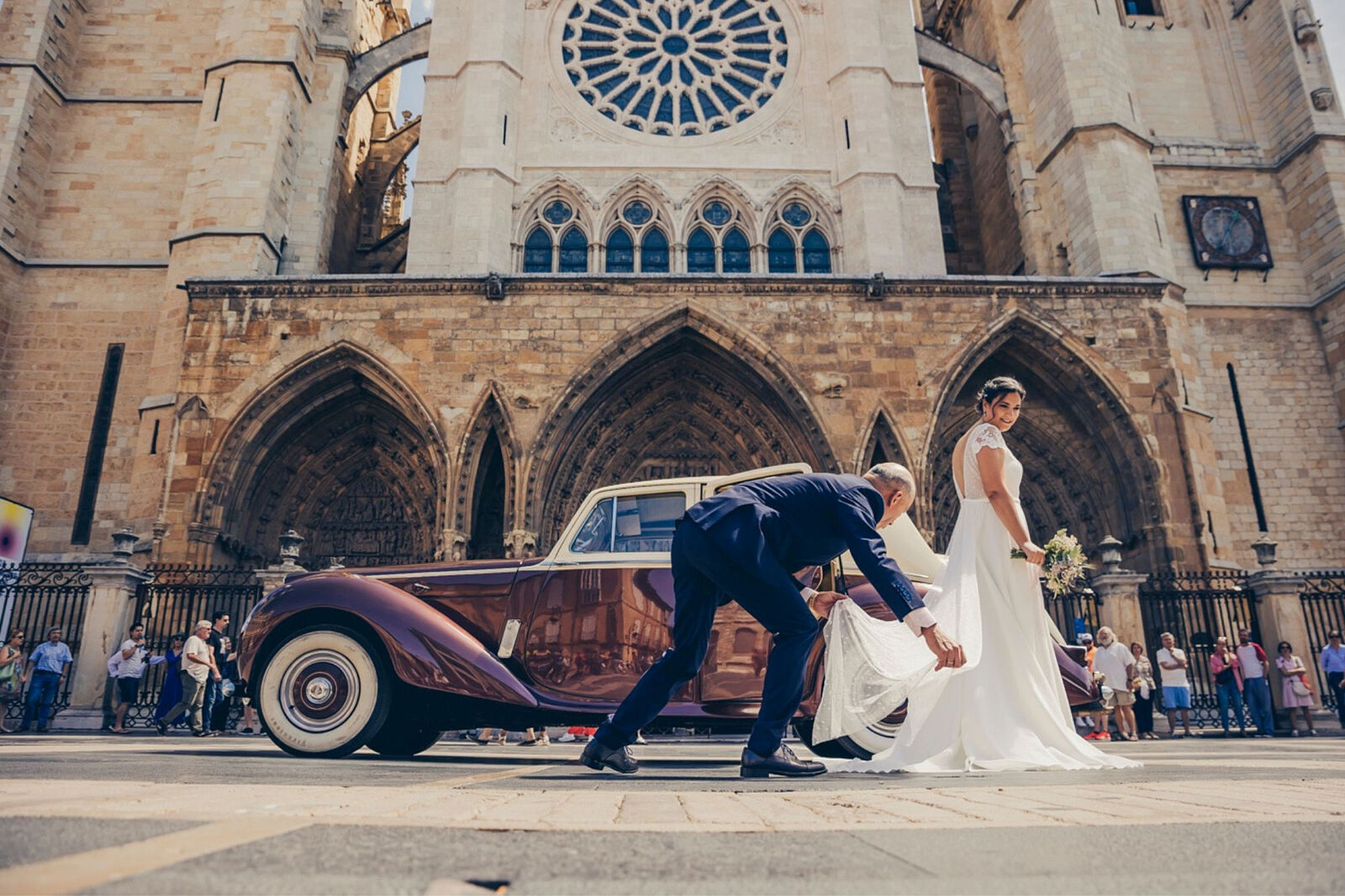 Novia llegando en coche clásico frente a la Catedral de León el día de su boda