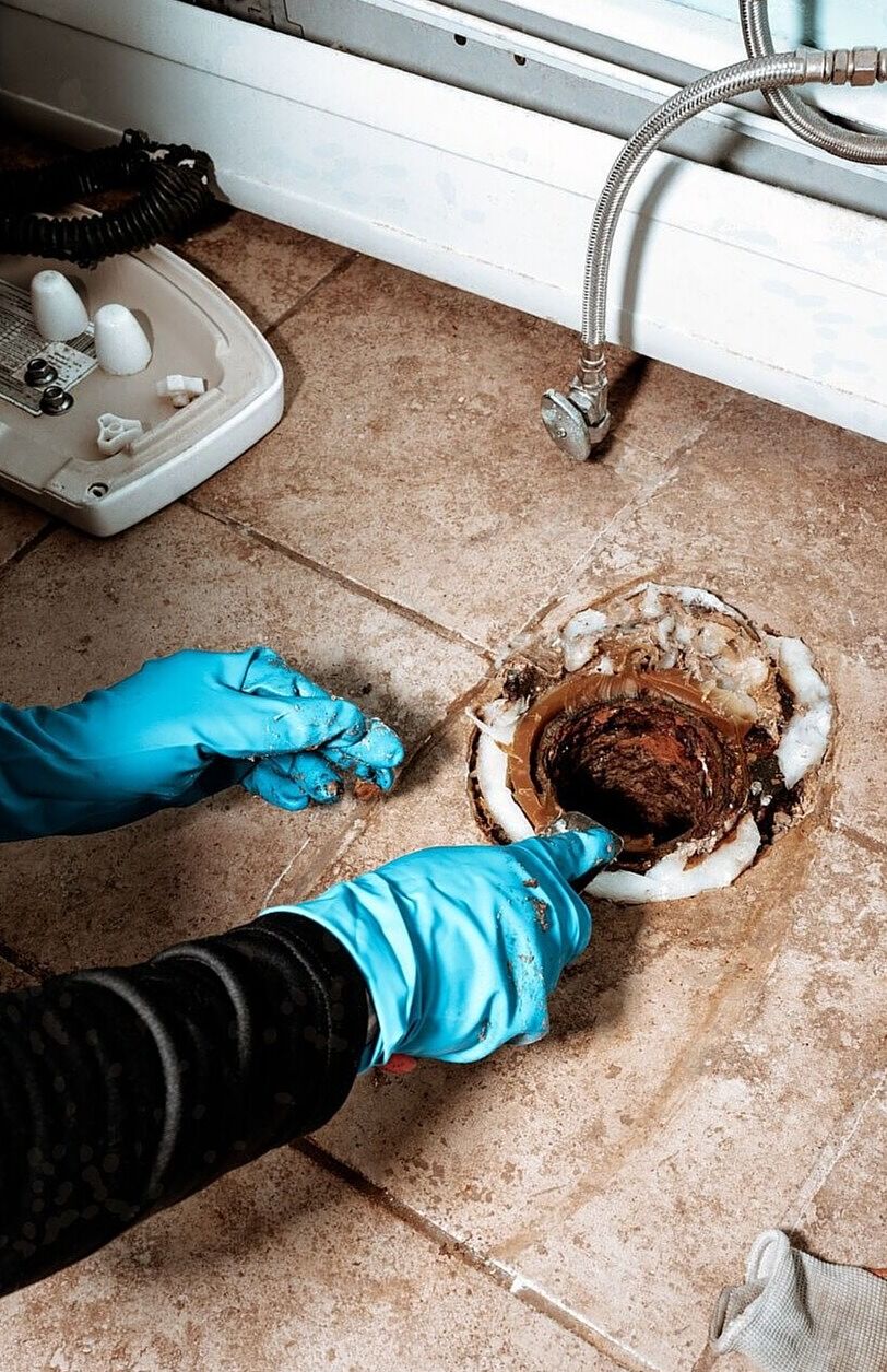 Close-up image of plumber replacing wax ring seal under a toilet with space for text – ideal for plumbing repair blogs and service websites