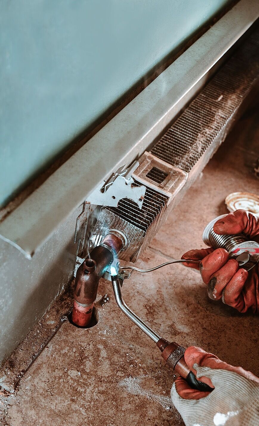 Close-up image of plumber replacing wax ring seal under a toilet with space for text – ideal for plumbing repair blogs and service websites