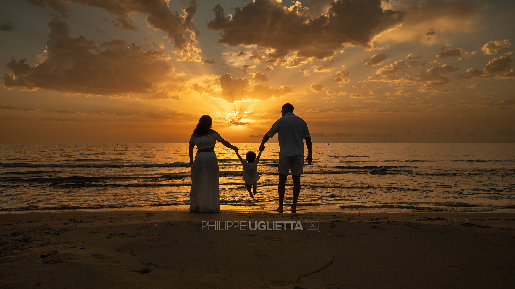 Sesion de fotos de una familia al amanecer en la playa