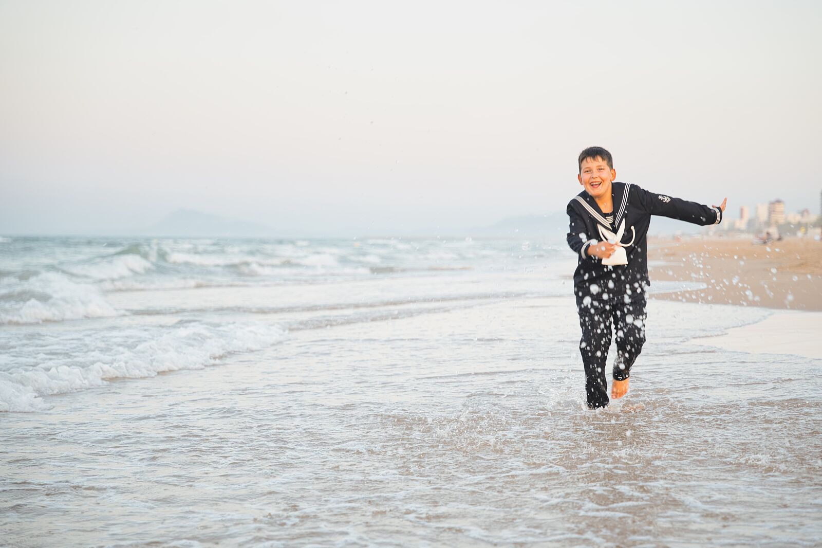 Niño jugando y corriendo en la orilla del mar en la playa de Gandía