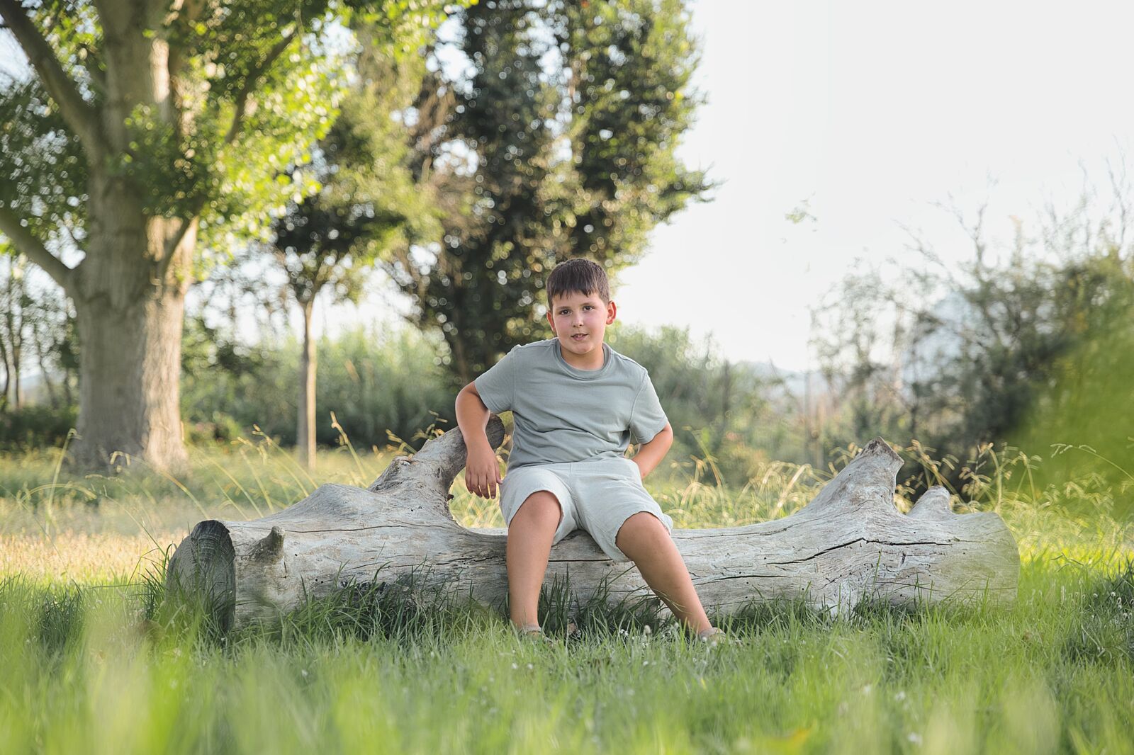 Niño apoyado sobre un tronco en la hierba de L’Estany de l’Ullal