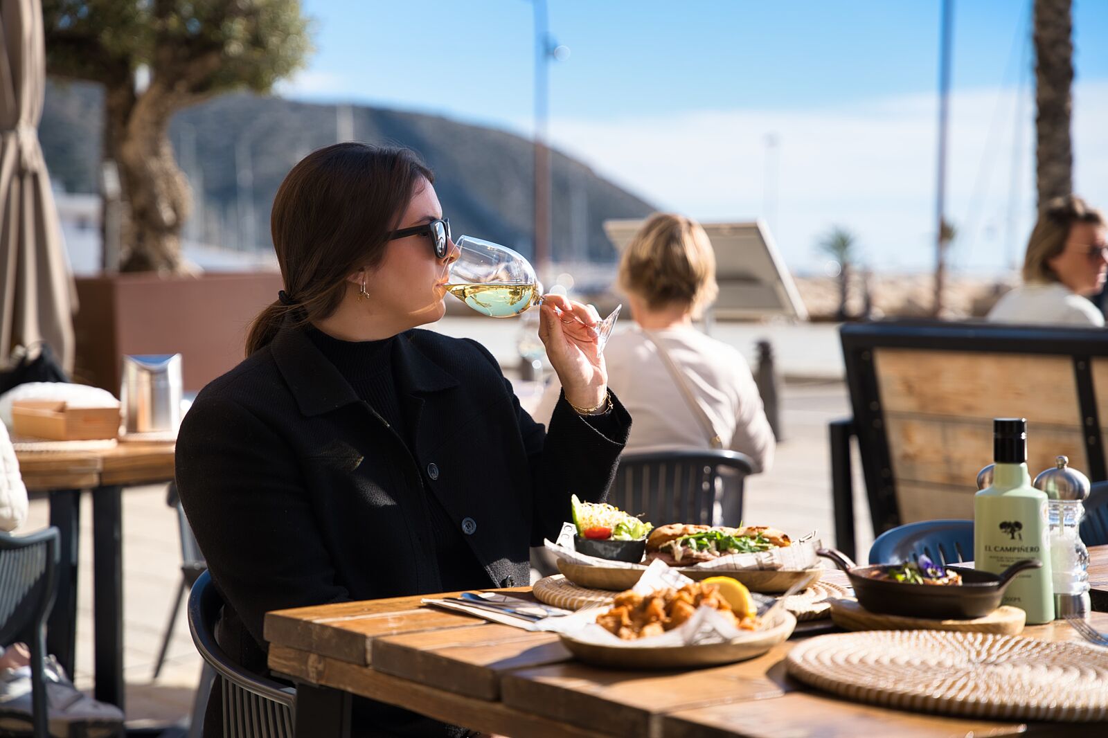 Clienta disfrutando en terraza del Restaurante Eleven con vistas al mar de Moraira. Fotógrafo Juan Reig.
