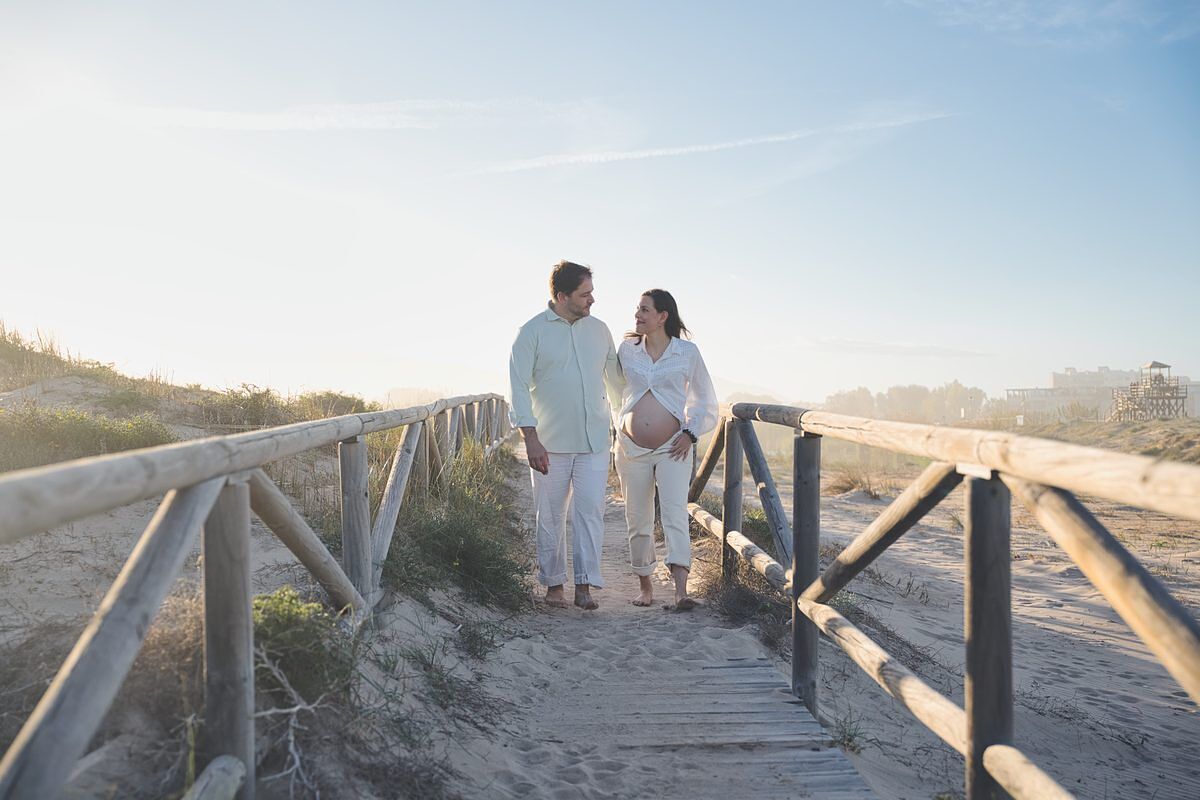 Pareja embarazada en el paseo de madera de la playa de Xeraco - Fotógrafo embarazo Gandía Juan Reig