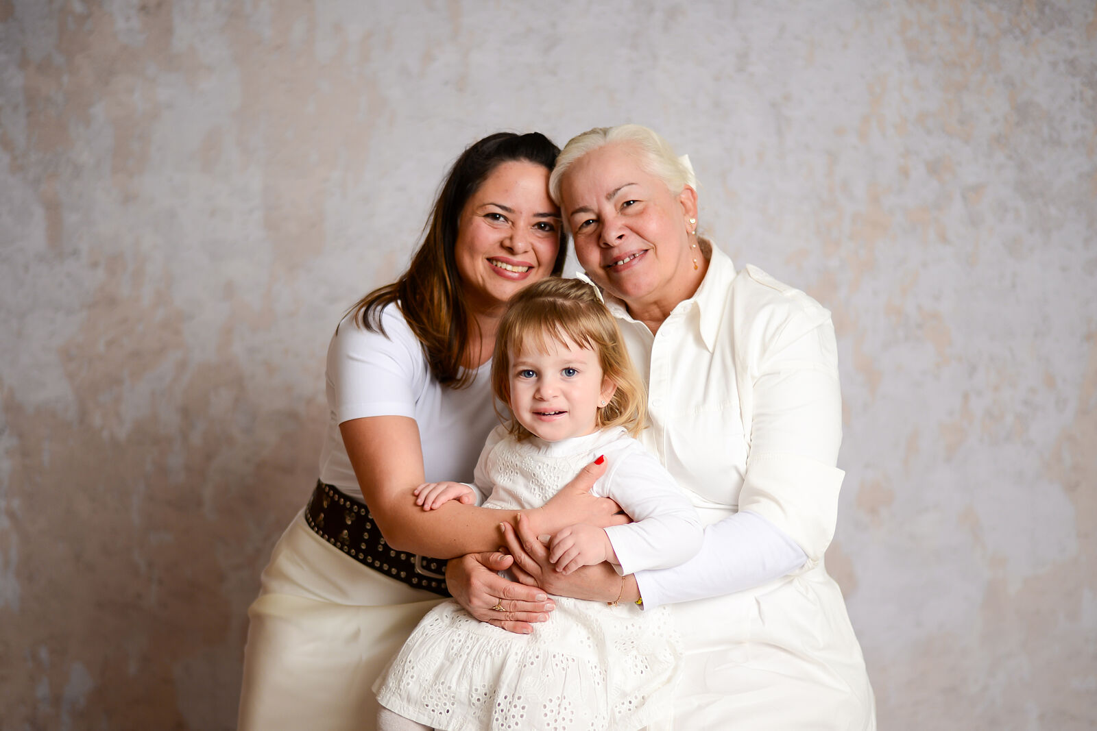 "Sesión de fotos familiar en estudio con padres e hijos sonriendo, Miluk Fotografía Madrid."