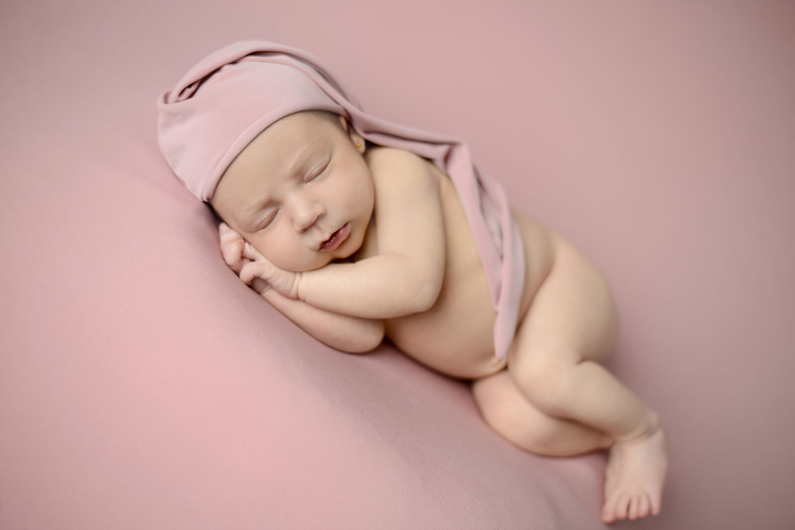 "Bebé recién nacido dormido con atrezzo artesanal, fotografía newborn profesional en Madrid."